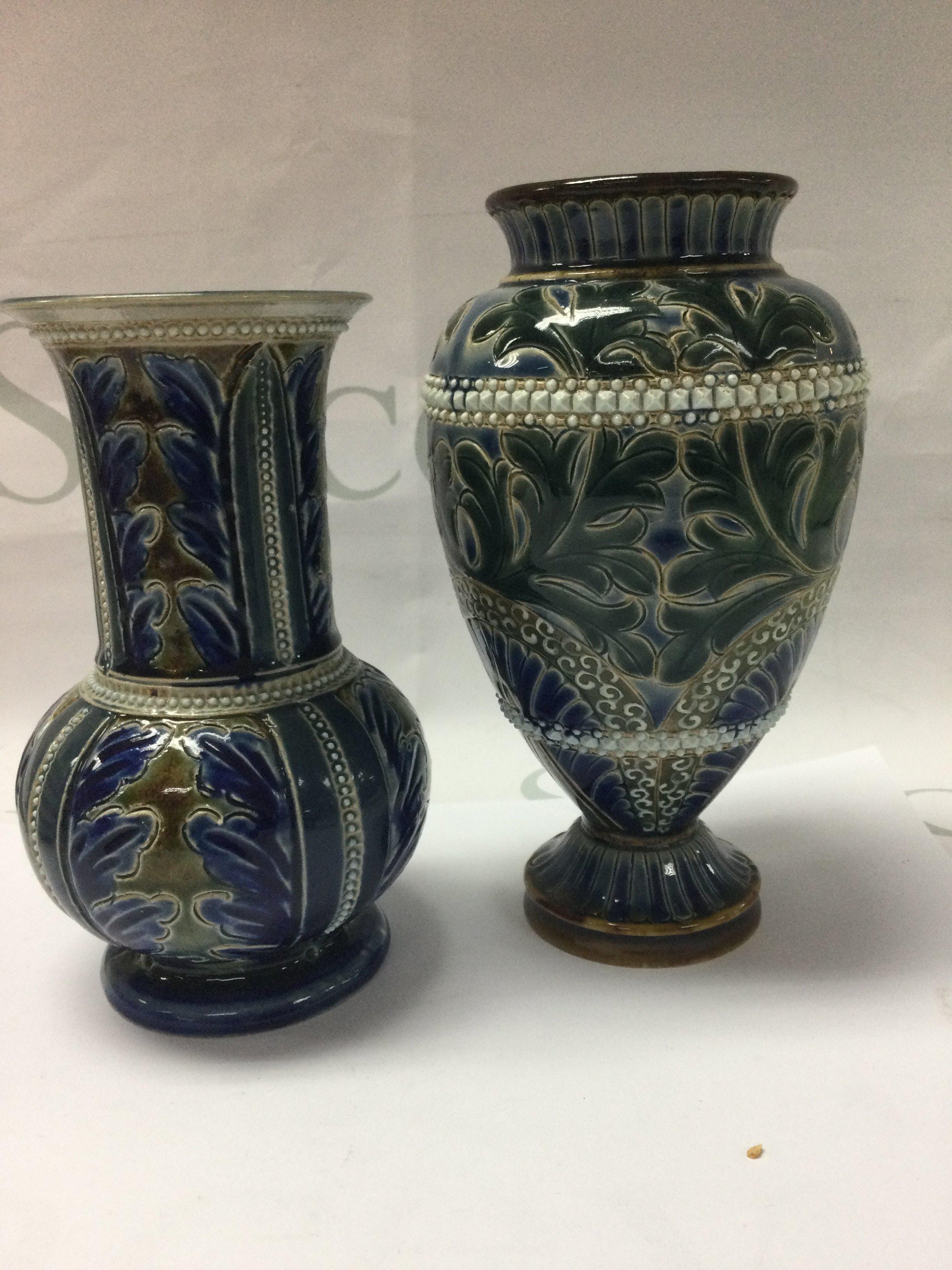 Two Doulton Lambeth vases decorated with foliage including ELisa Simmannce 16 cm and 18 cm .