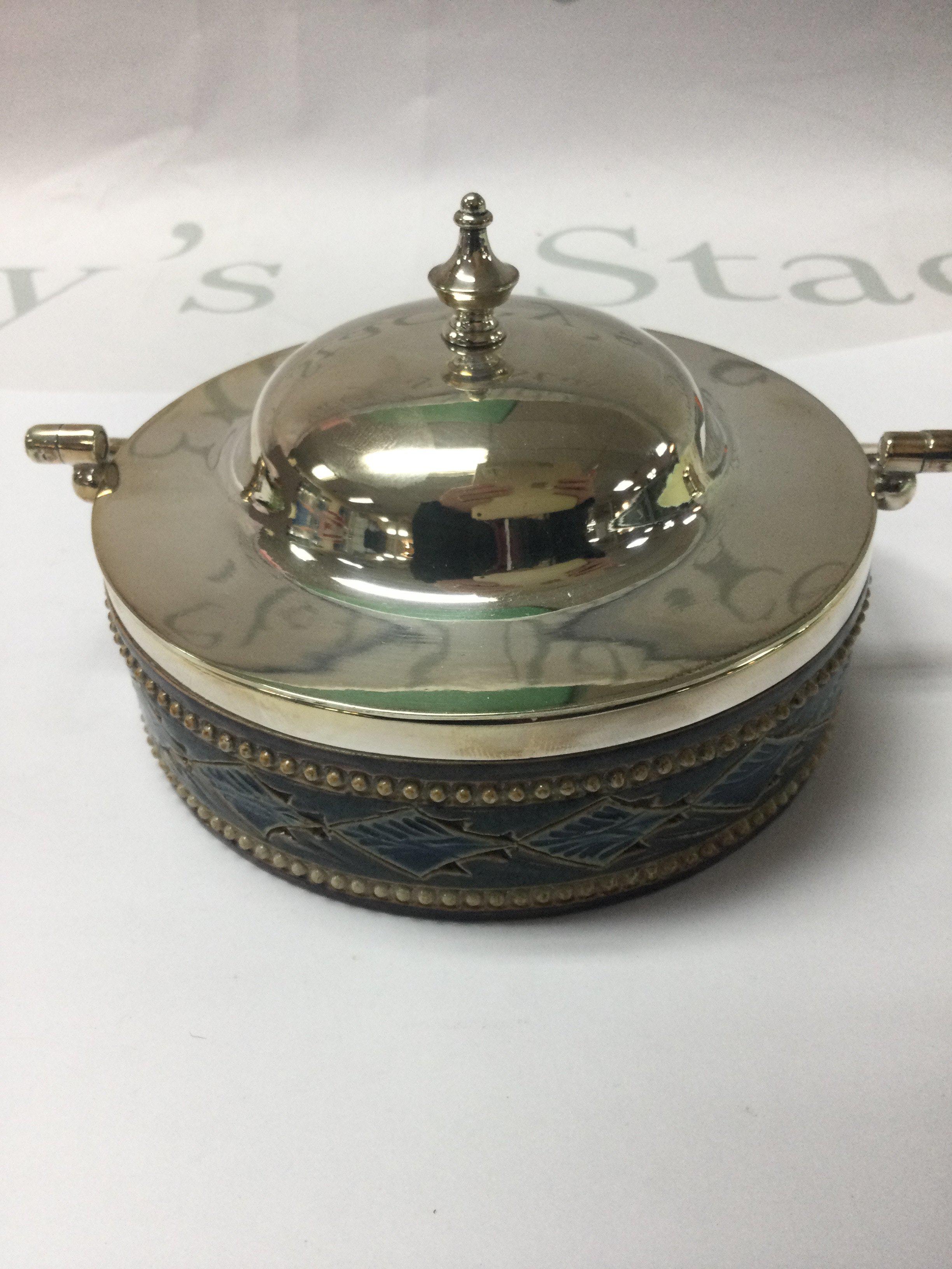 A Doulton Lambeth preserve jar with silver plated cover .