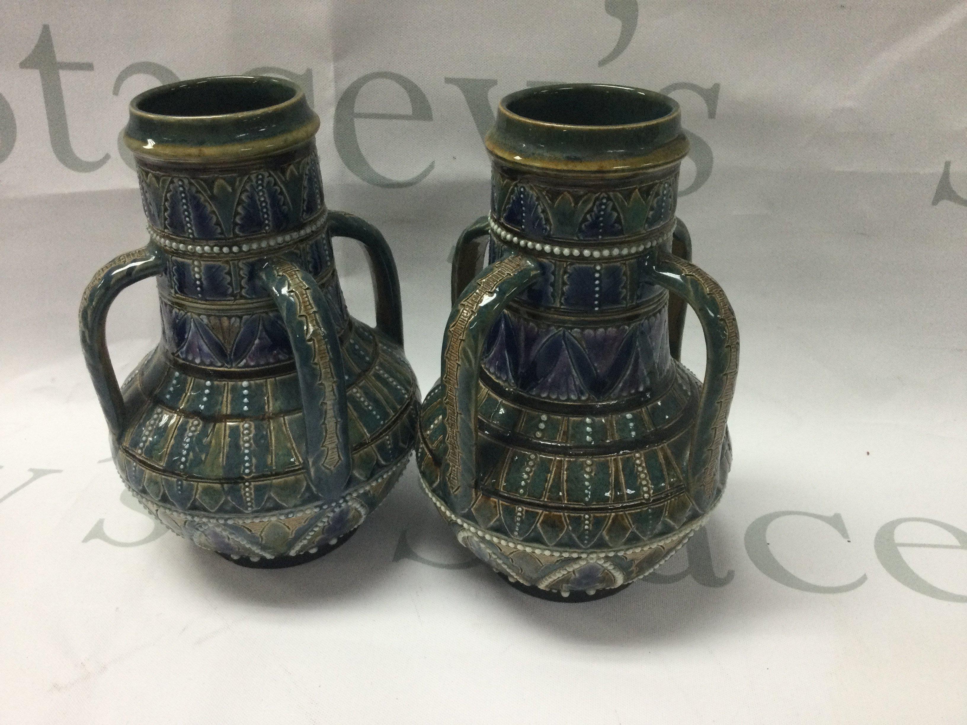 A pair of Doulton Lambeth four handled vases 14 cm .