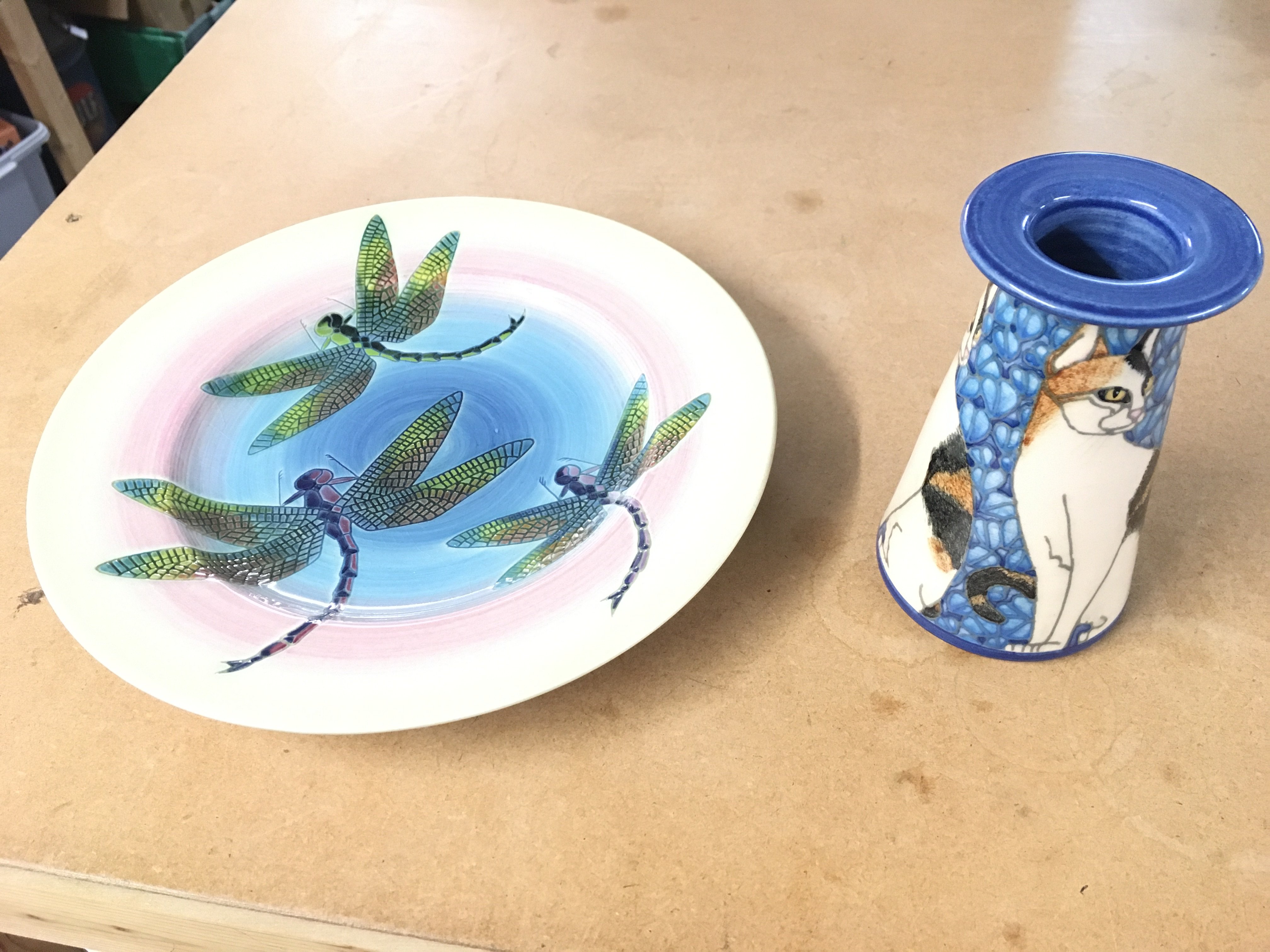 A Dennis China works cat vase by Sally Tuffin along with a Dragon fly plate also by Sally Tuffin Both in good condition with no obvious damage.
