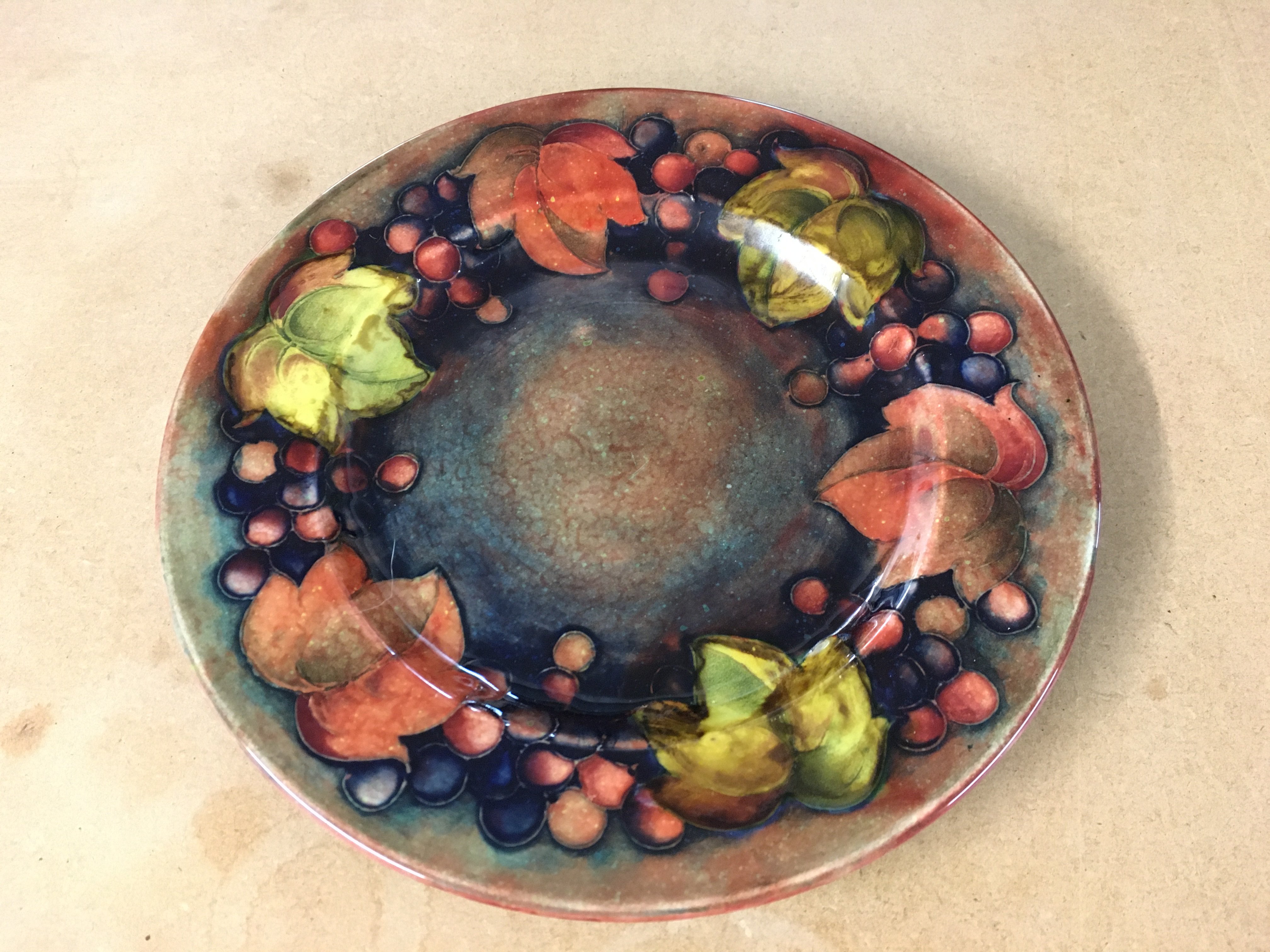 A Moorcroft Flambe leaf and berry plate. 23cm diameter. Good condition