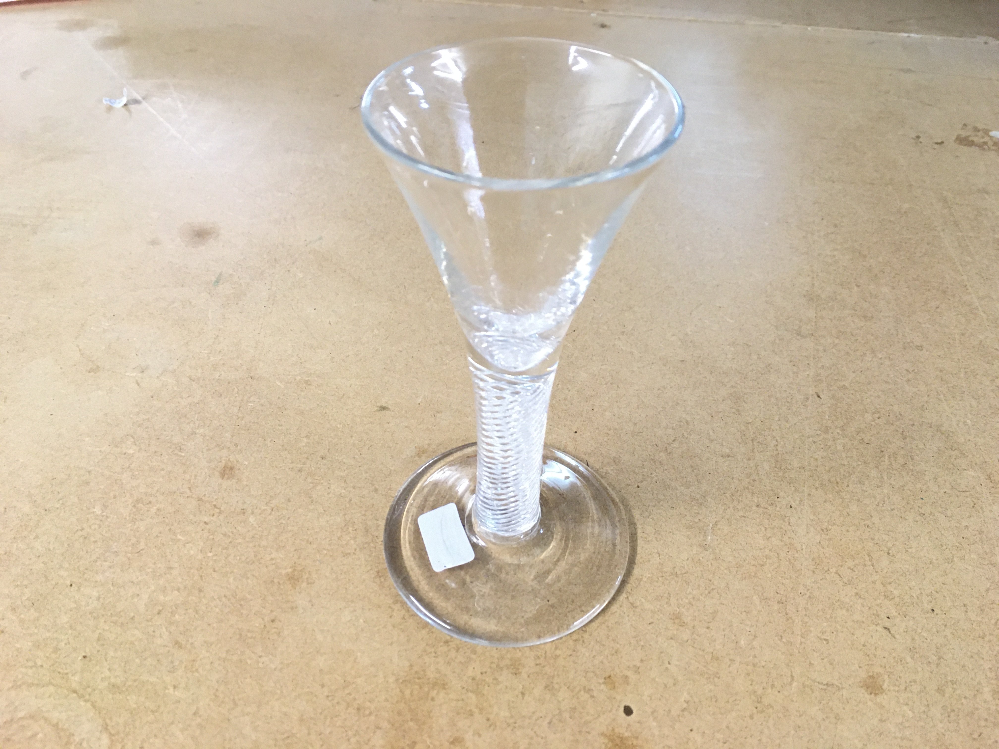 An 18th century drinking glass circa 1750 a drawn trumpet bowl above an air twist stem rasied to a circular spread foot. 13cm tall. Good condition with no obvious damage.
