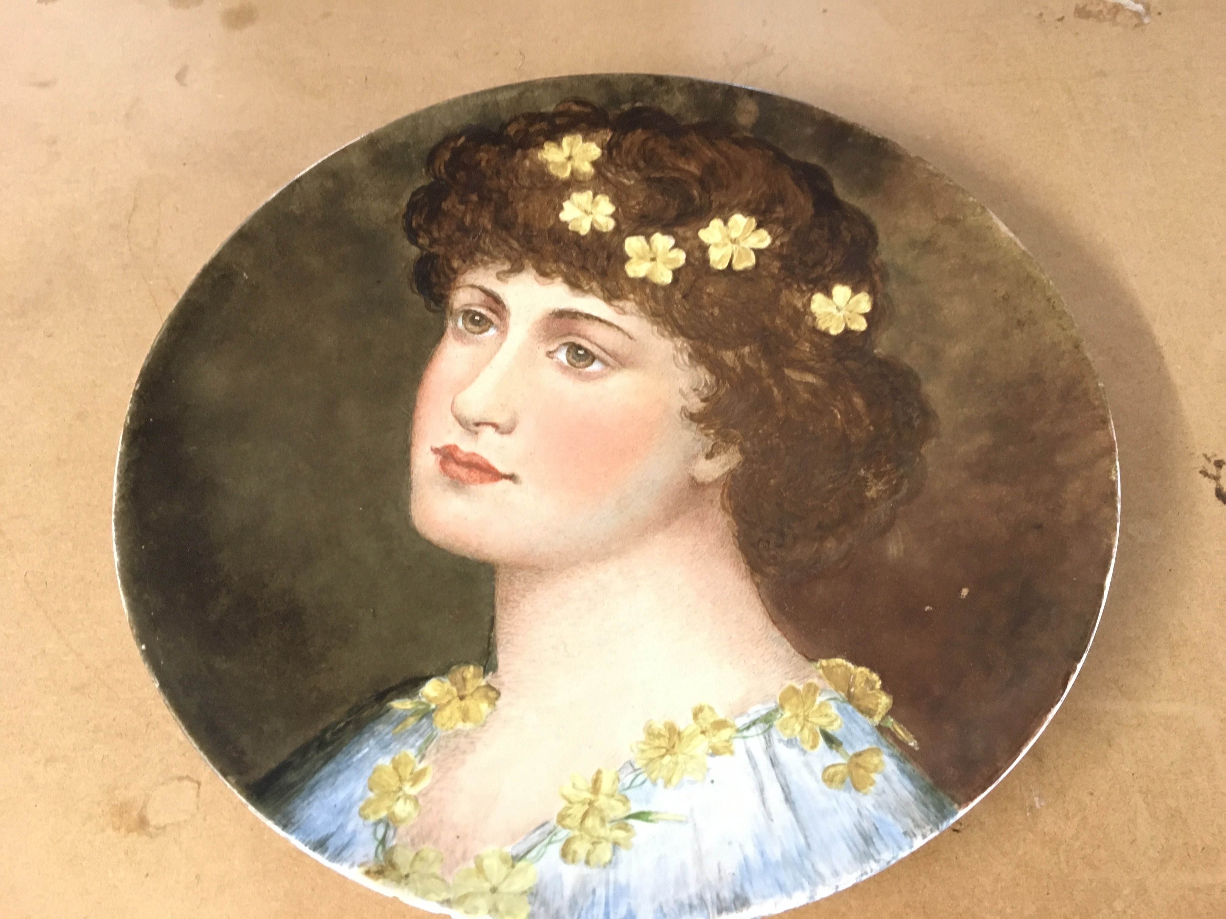 Moore & Co late 19th century charger in the arts and crafts style decorated with a hand painted portrait of a lady with a yellow flower in her hair. Impressed Brown westhead moore and co. Diameter 37cm.
