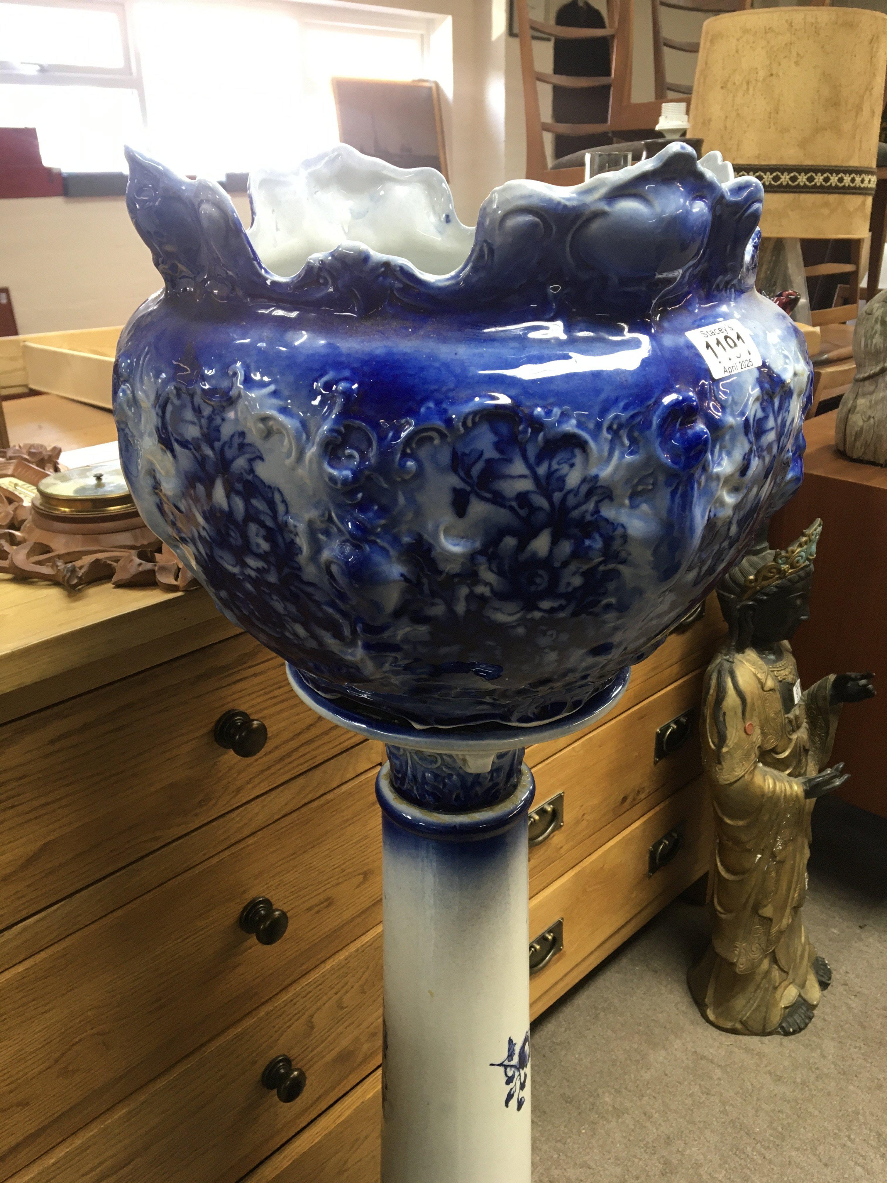 A late Victorian flow blue ceramic jardiniere with a shaped edge on a similar blue ceramic column.