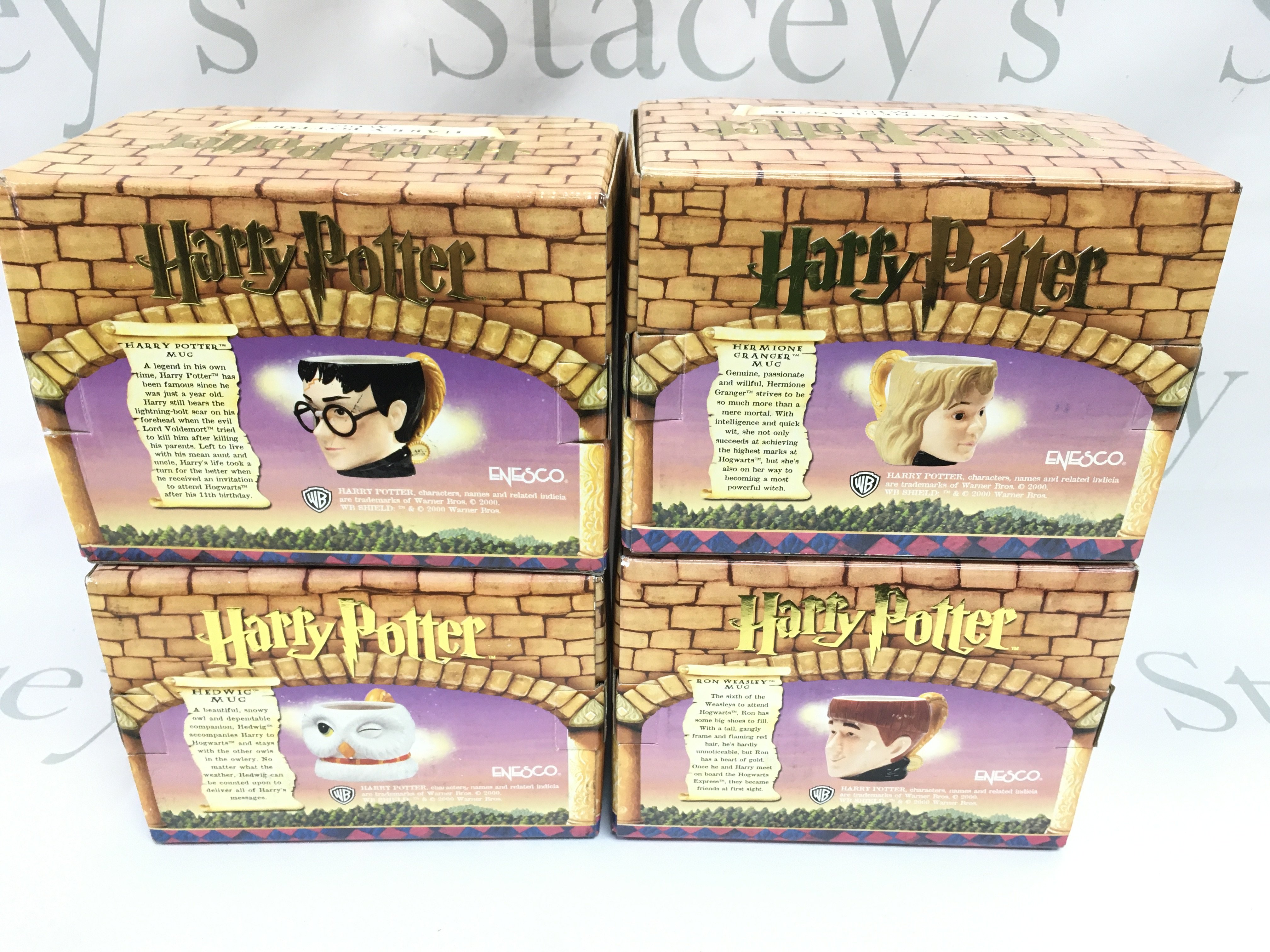 A collection of four boxed Harry Potter mugs by Enesco including Harry Hermione Ron and Hedwig