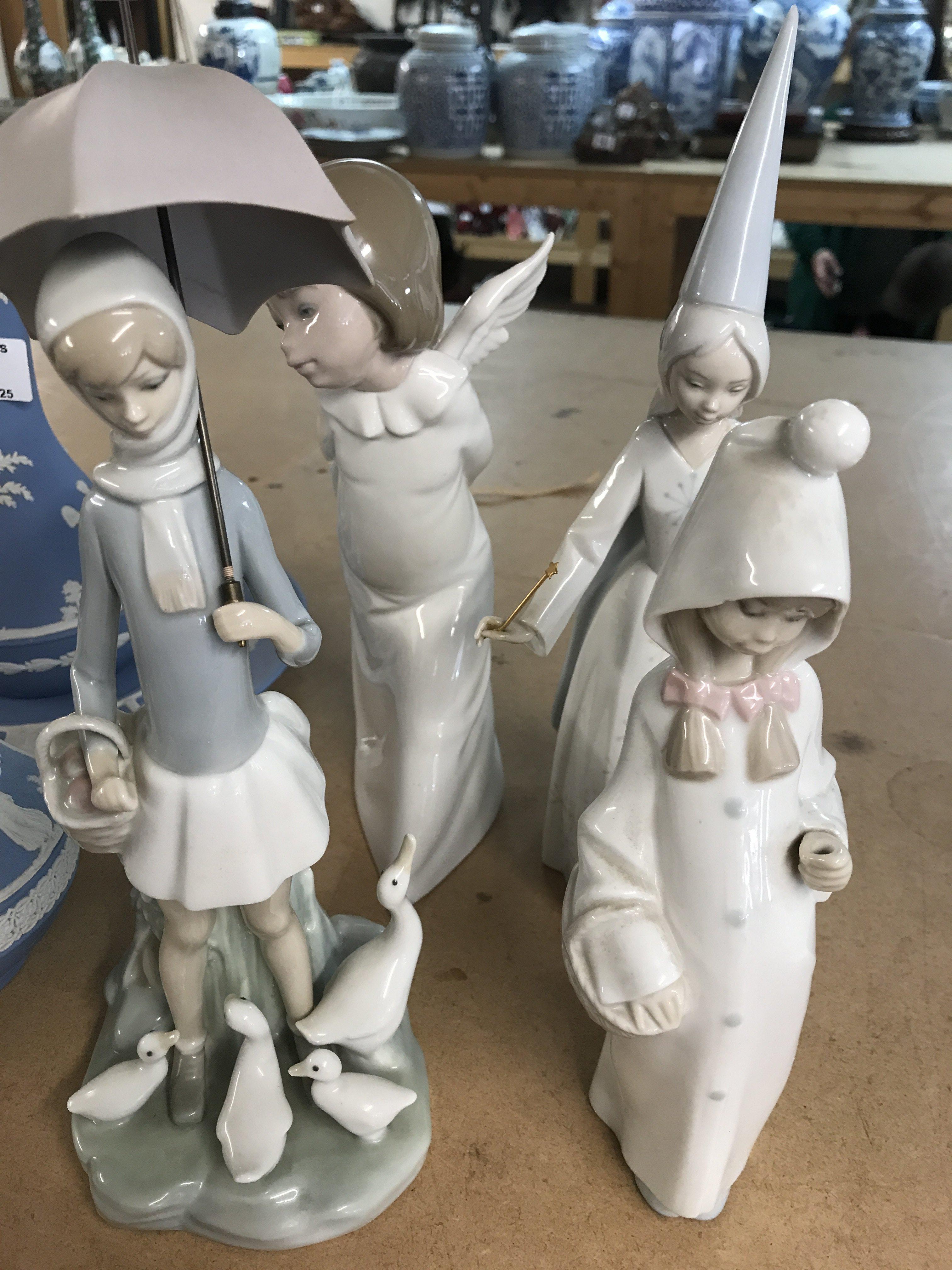 A collection of four Lladro figures .