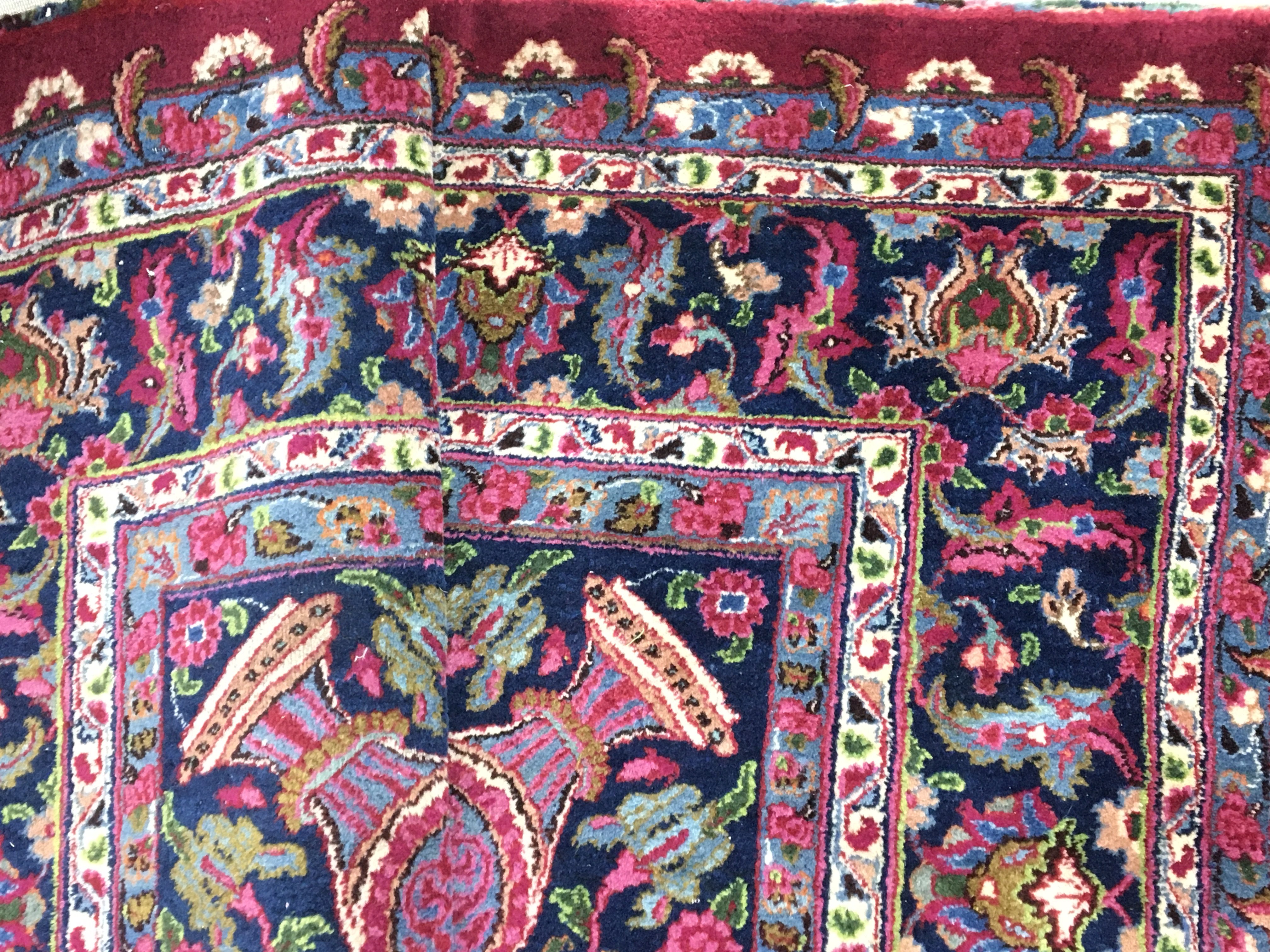 A large hand knotted rug with vibrant colours. Approximately 390 cm by 300