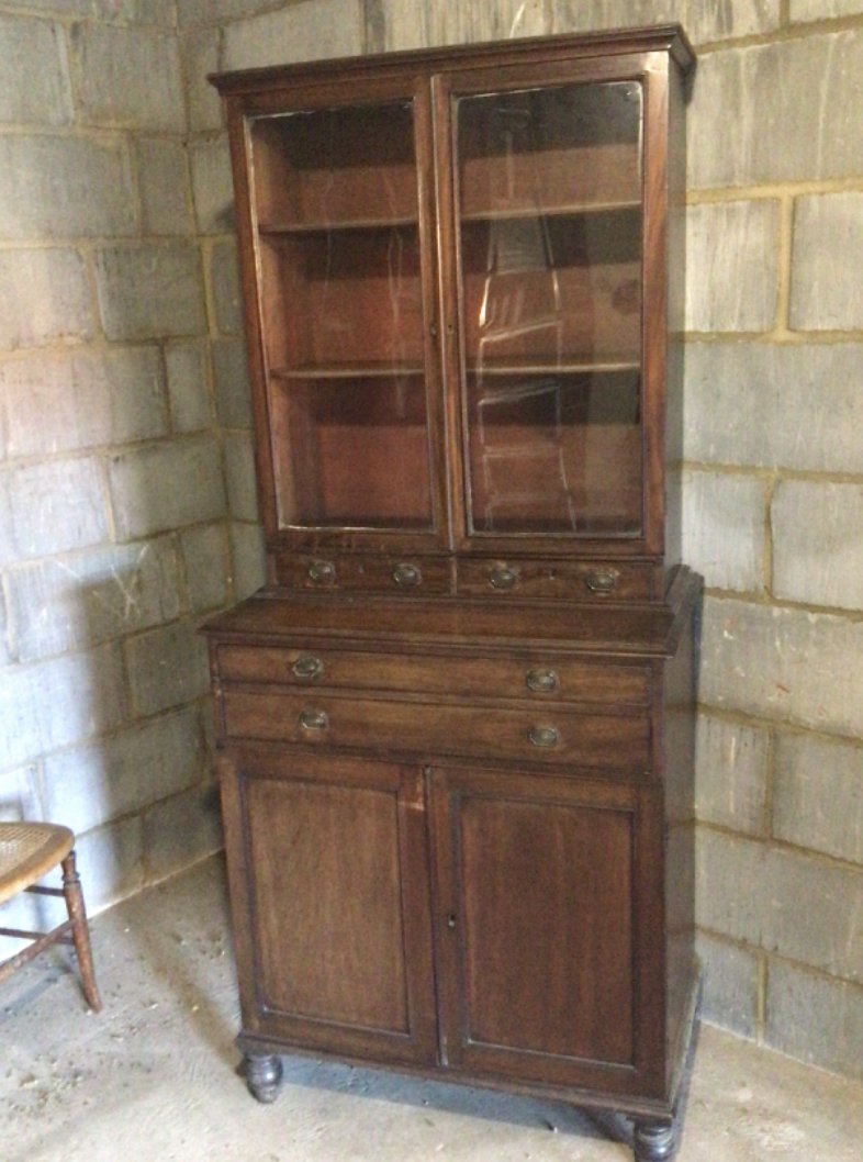 An Early 19th century late Regency Mahogany cabinet with glazed doors above small drawers and cupboards. 180cm heigh 80cm wide approximately.