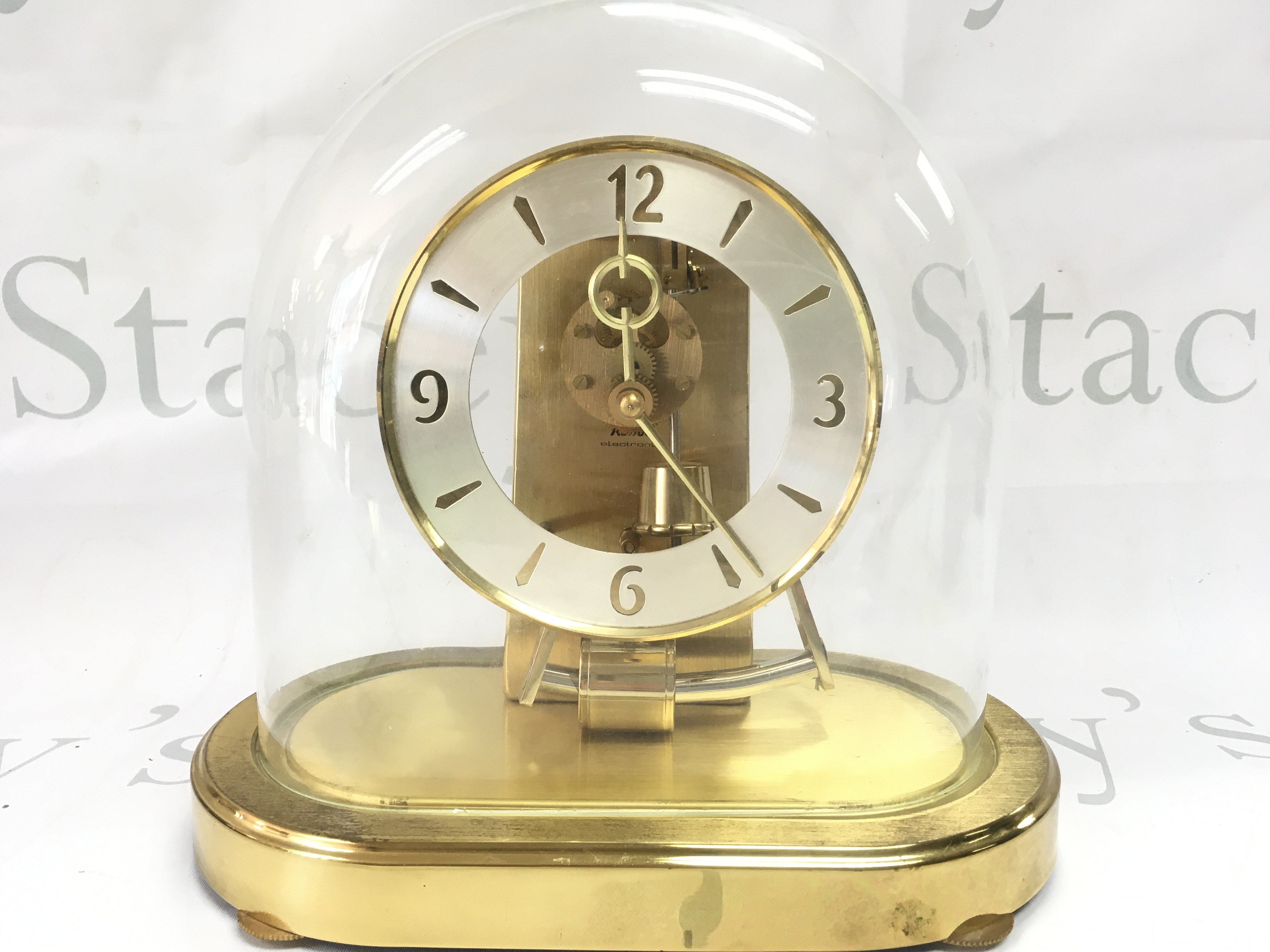 A mid 20th century Kunda West German clock under a glass dome, for restoration