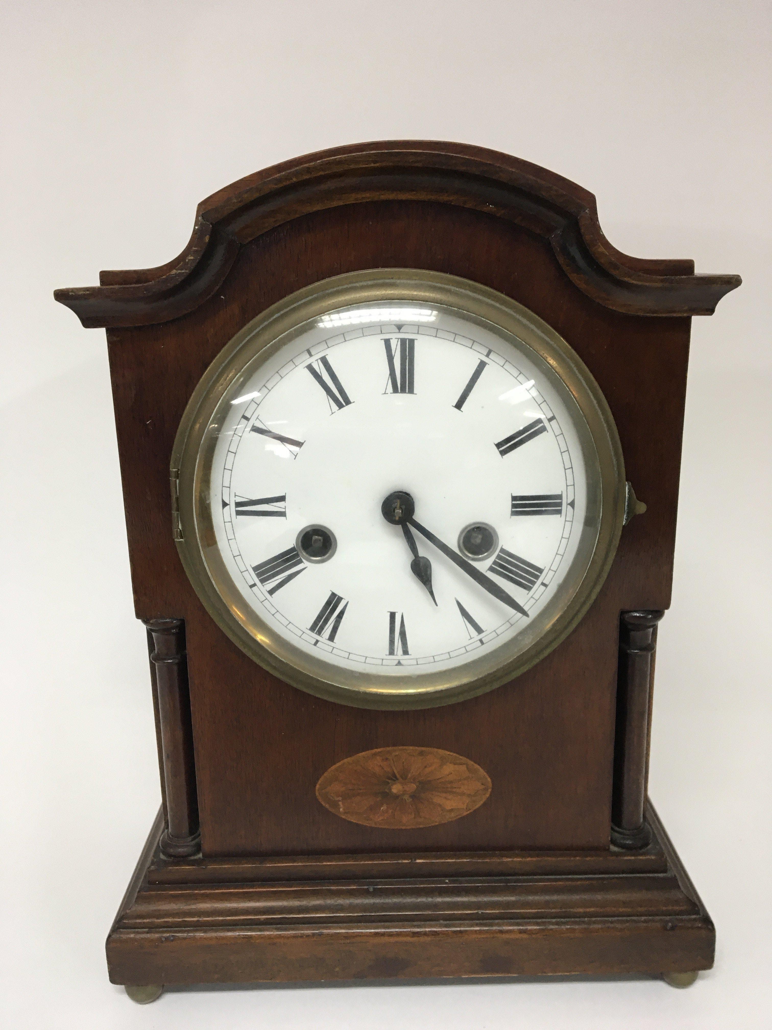 An Edwardian inlaid mahogany mantel clock with an enamel dial brass movement striking on a gong with pendulum height 32cm