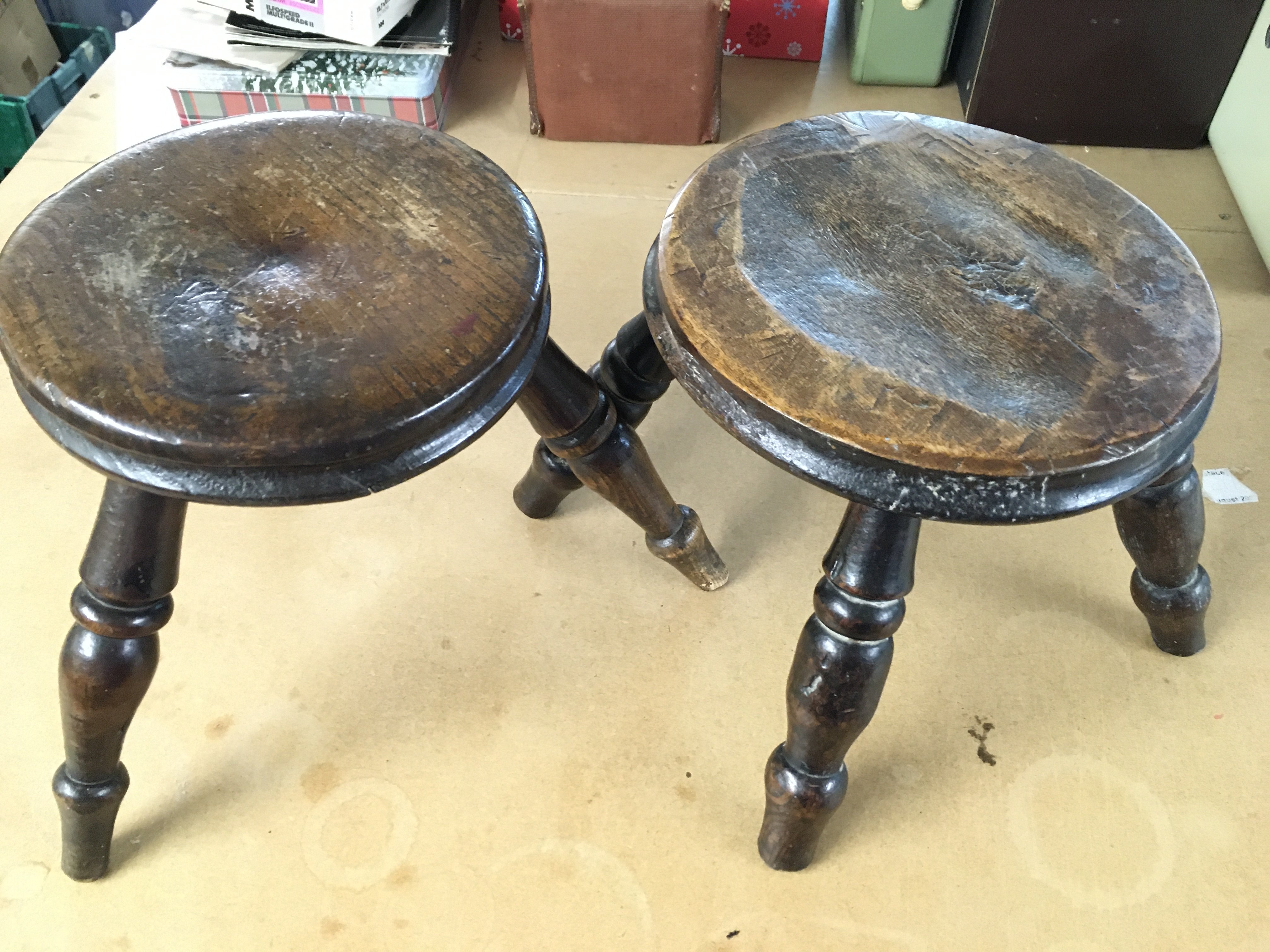 A three legged milking stool 8.5" tall and a four legged milking stool 7.5" tall. Postage C
