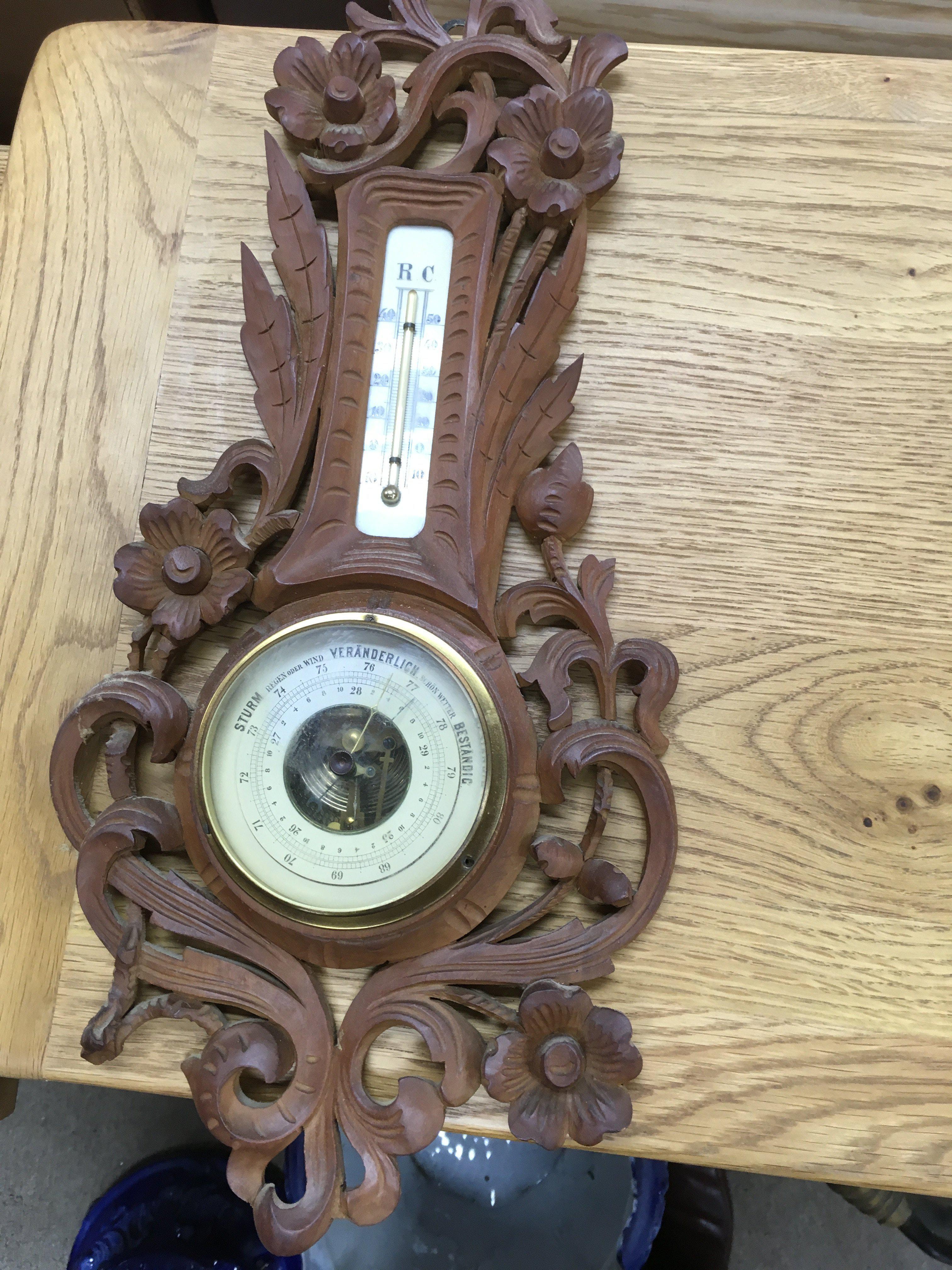 A small oak Black Forest carved wall barometer.