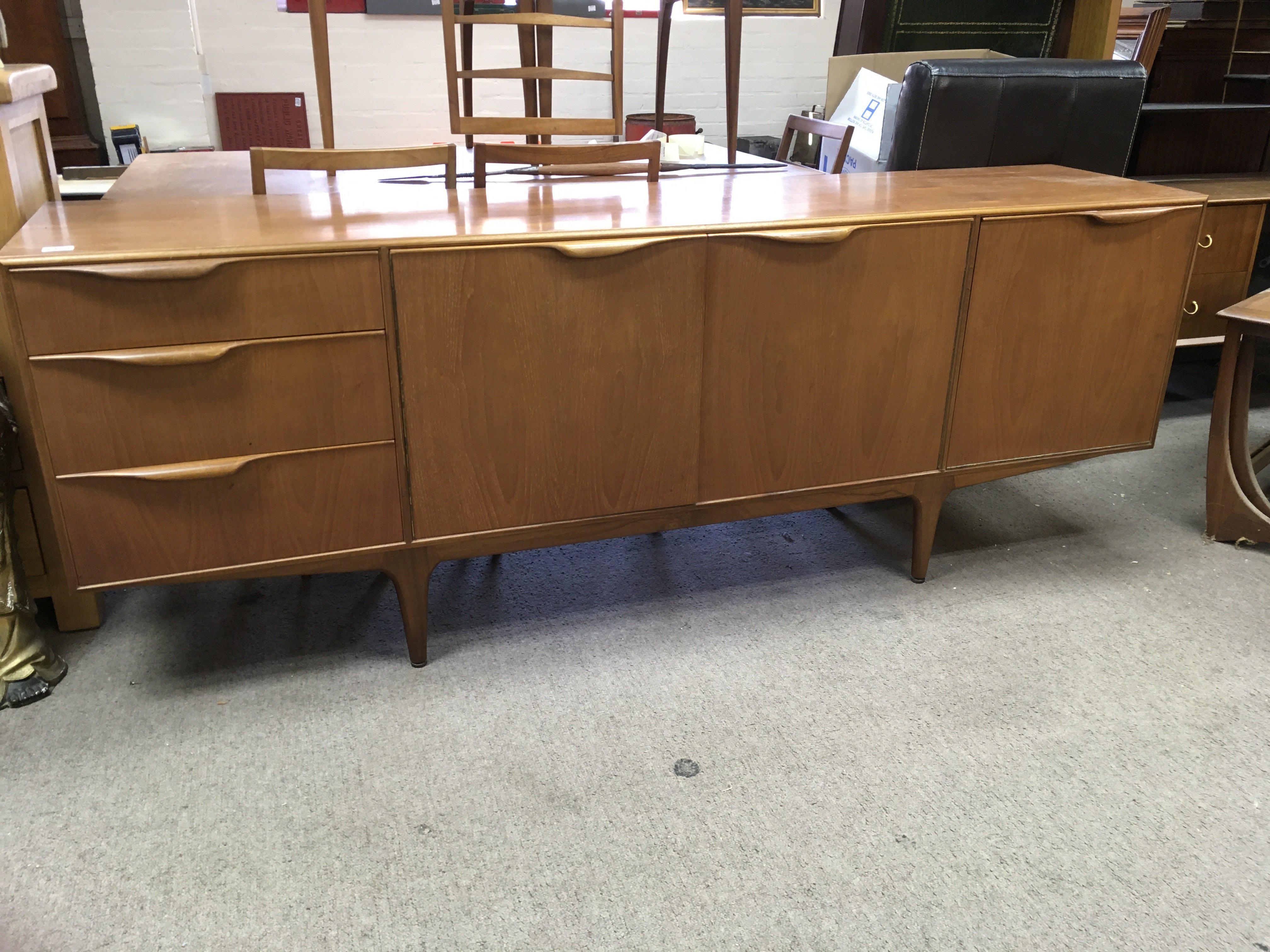 A teak 1970s sideboard fitted with cupboards and doors together with table and six chairs .