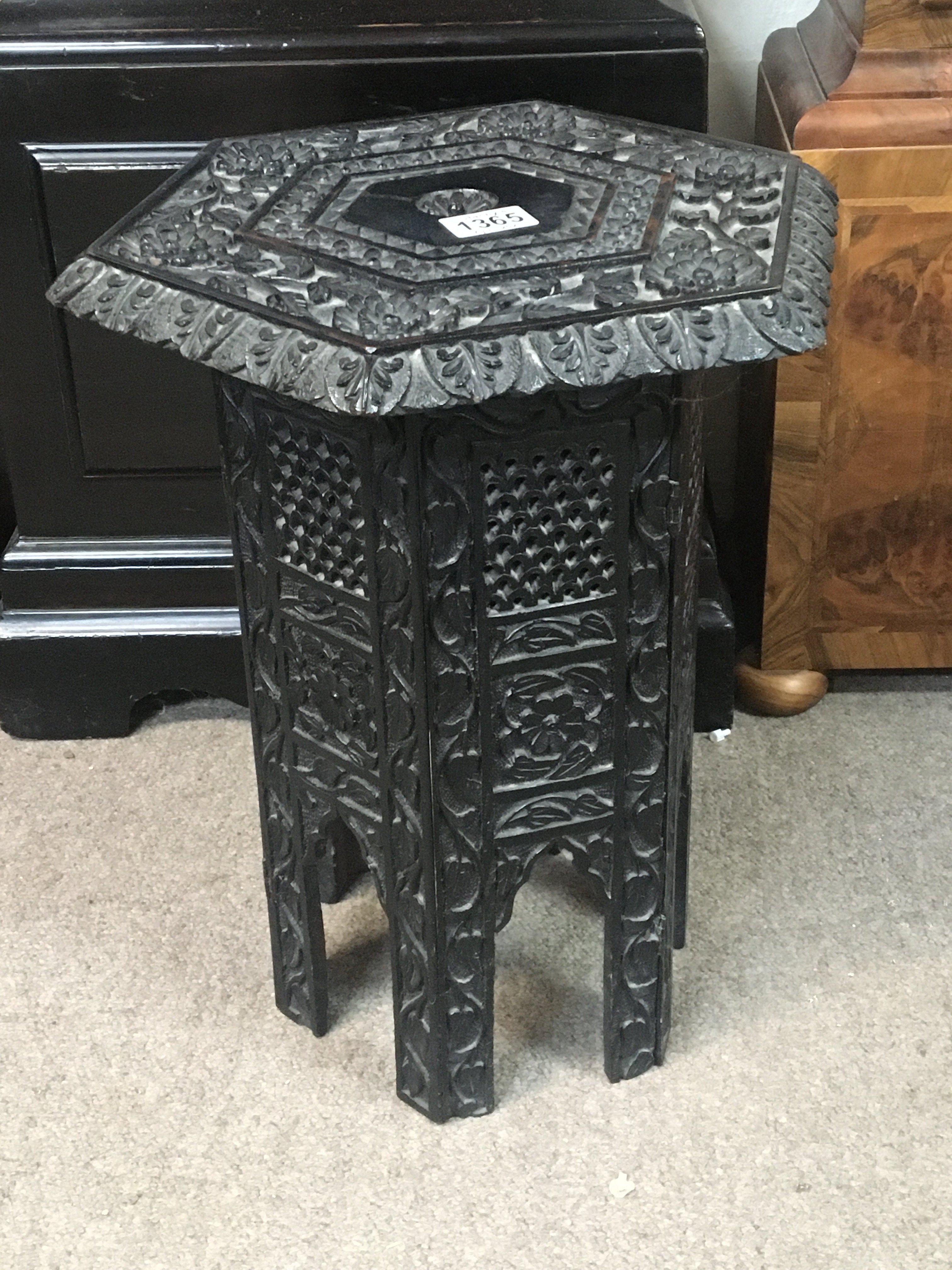A Middle Eastern type carved hardwood occasional table the hexagonal top on a folding stand Hight 45cm
