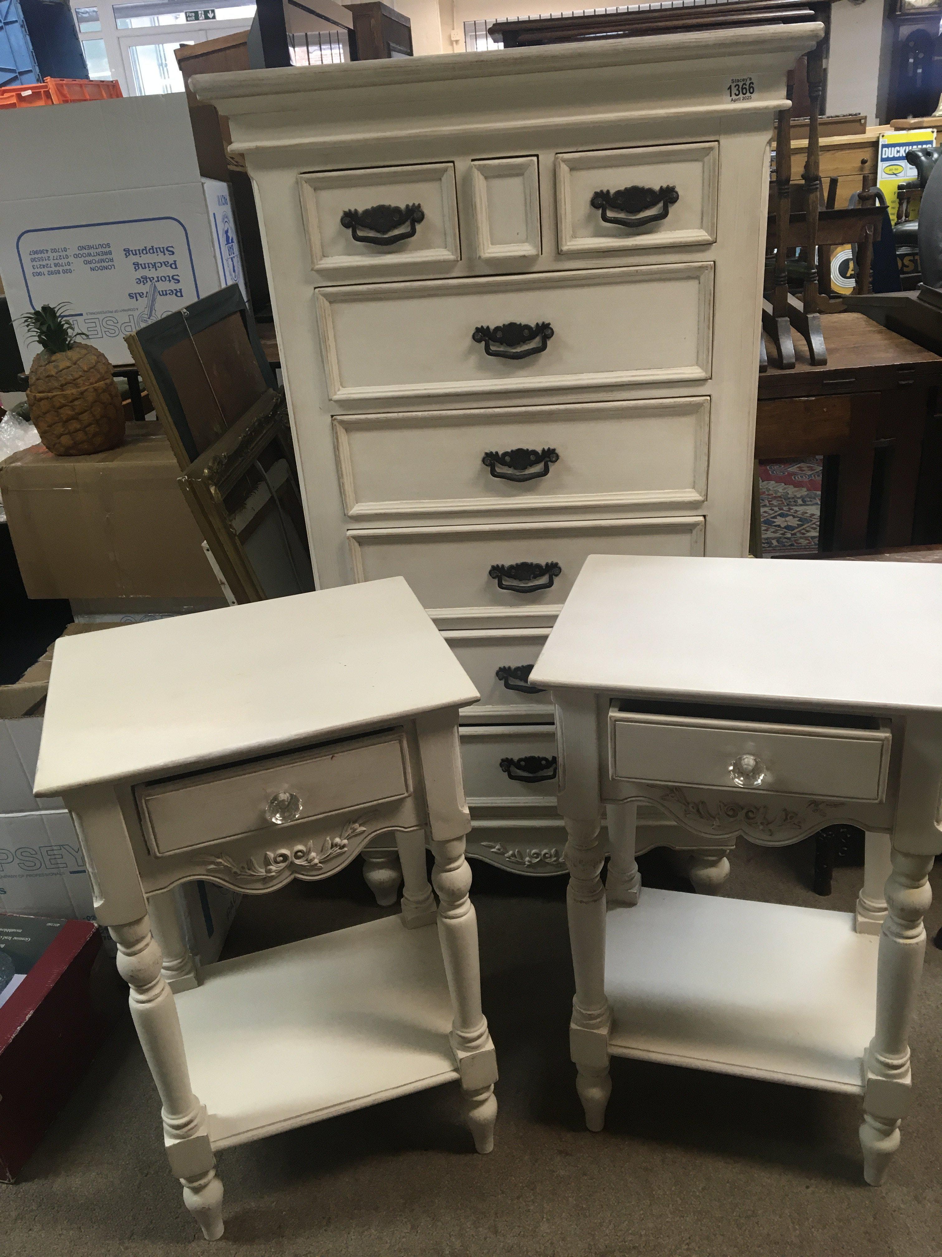 A white painted chest of drawers and a pair of white painted conforming bedside tables