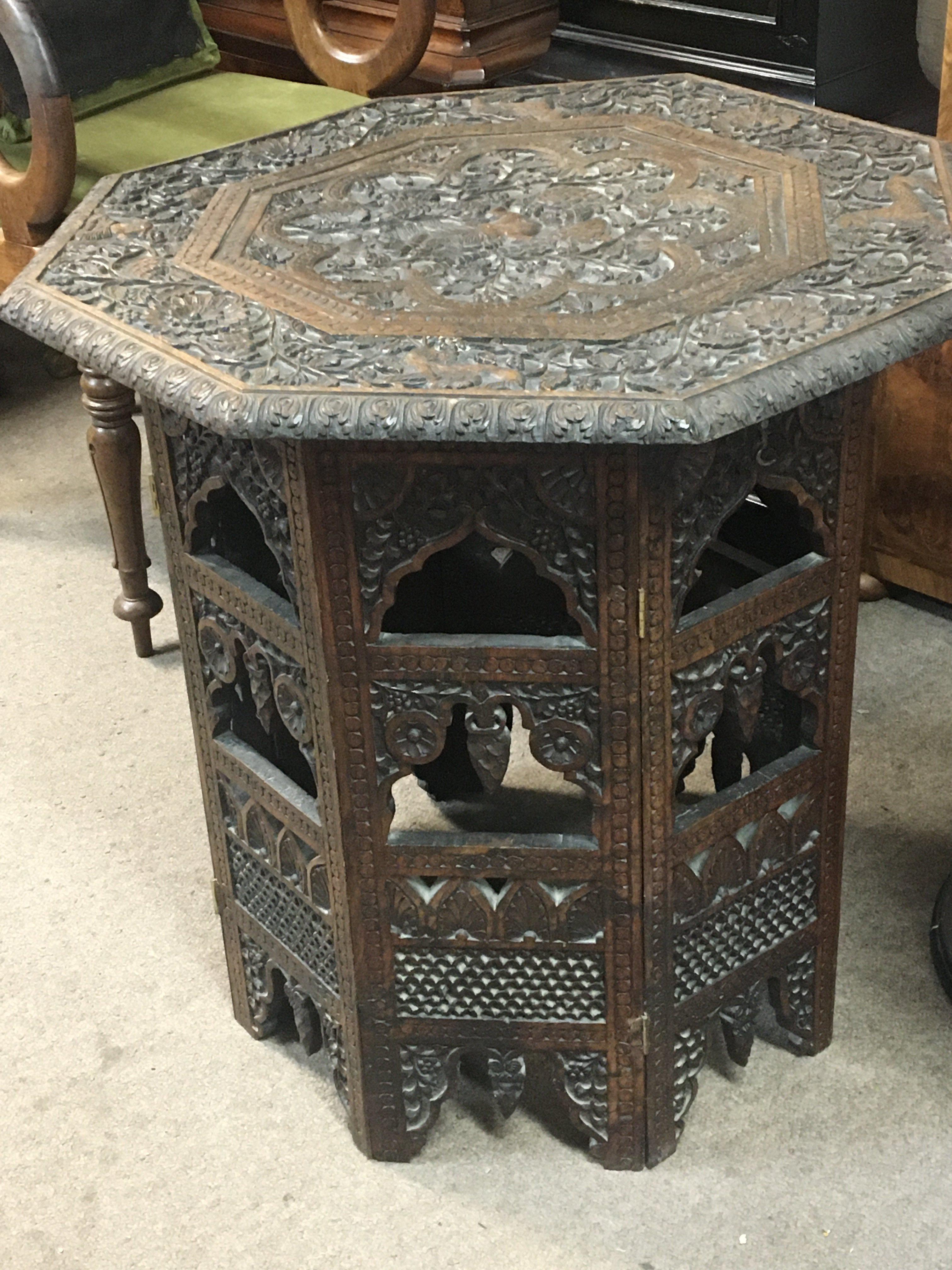 A late 19th century carved hardwood octagonal top card table with both Indian and Middle Eastern influence.
