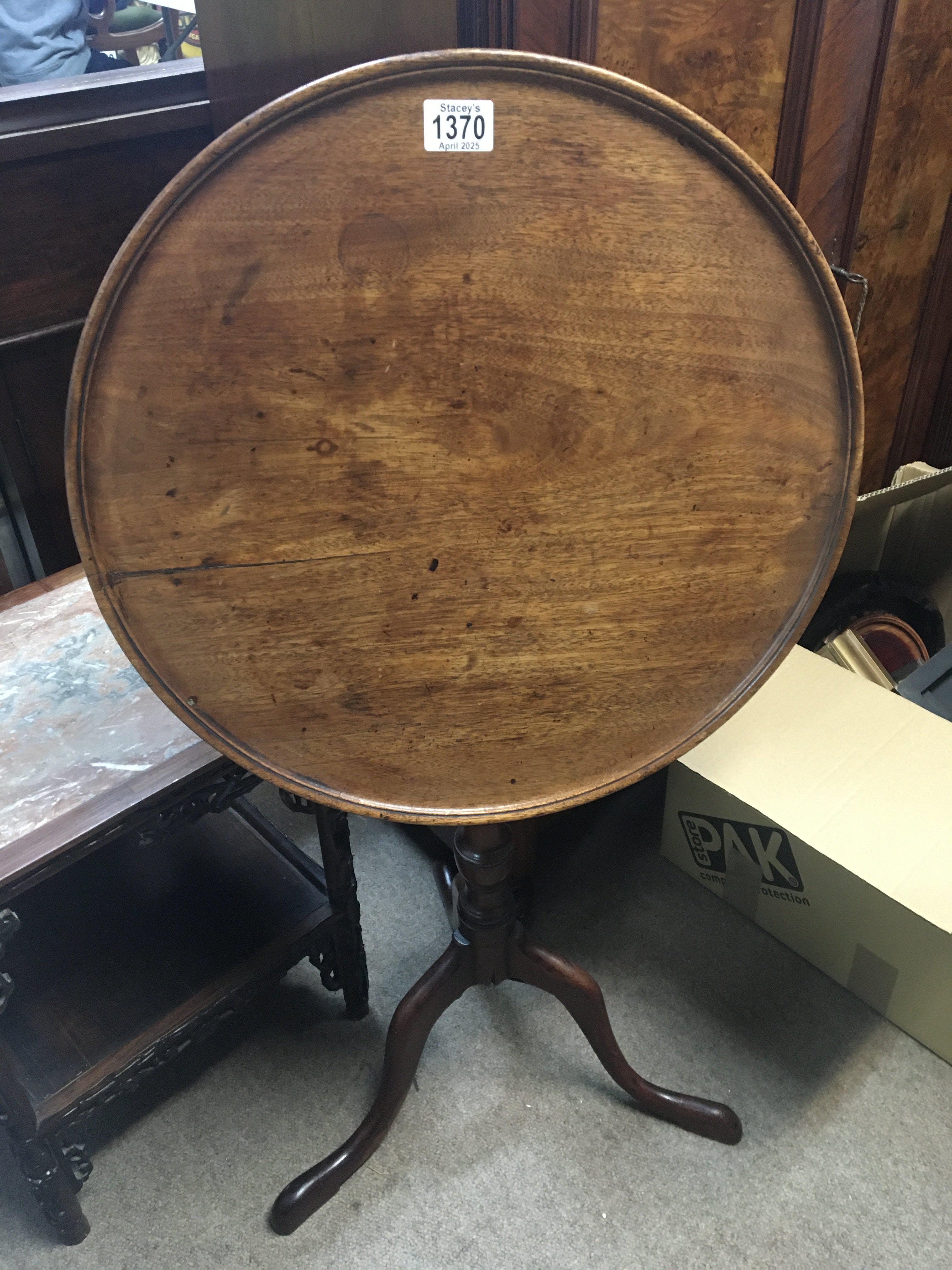 A George III mahogany tip action wine table with a circular top on a turned column. top diameter 49cm