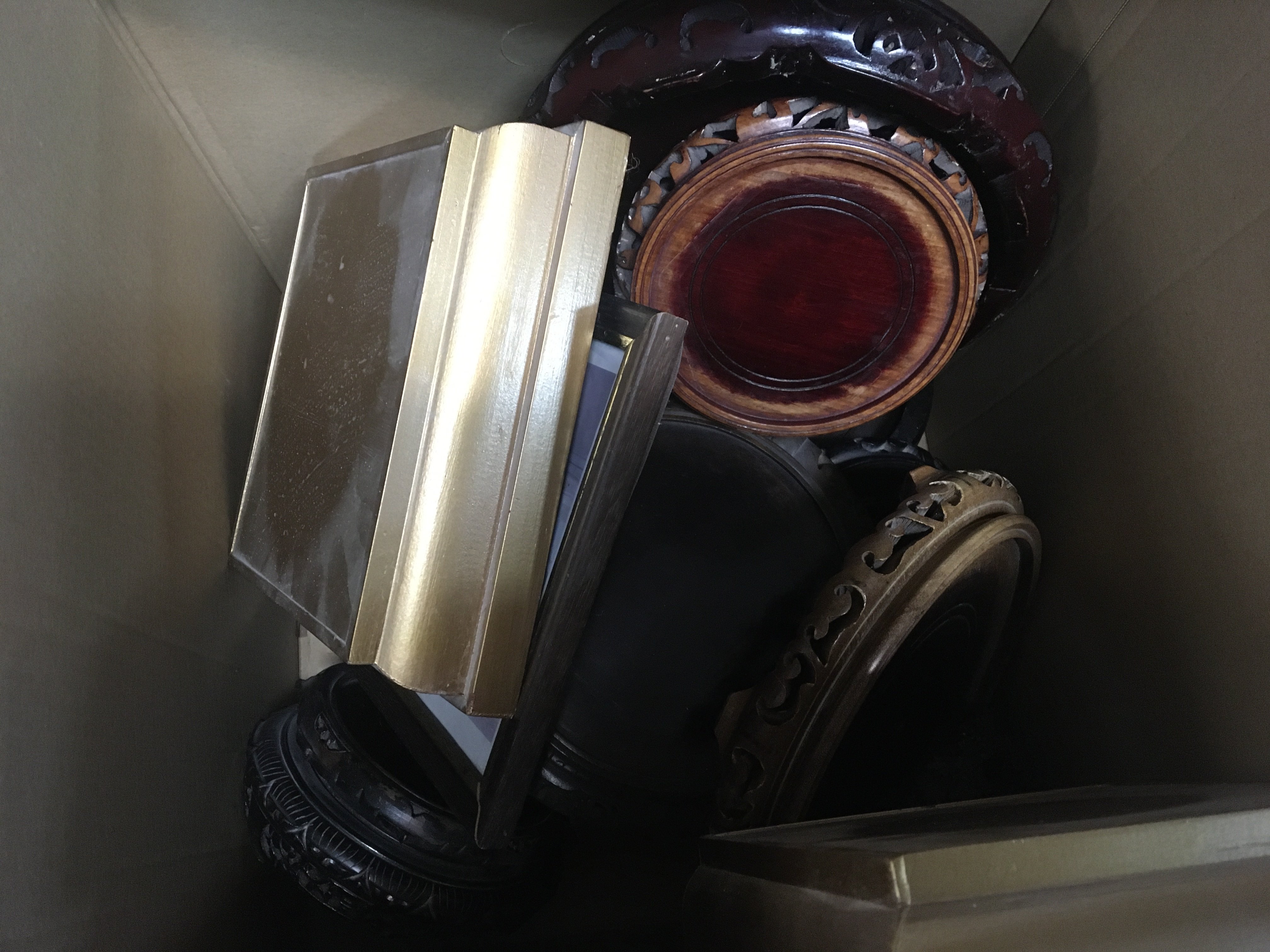 A box containing a collection of carved hardwood oriental stands.