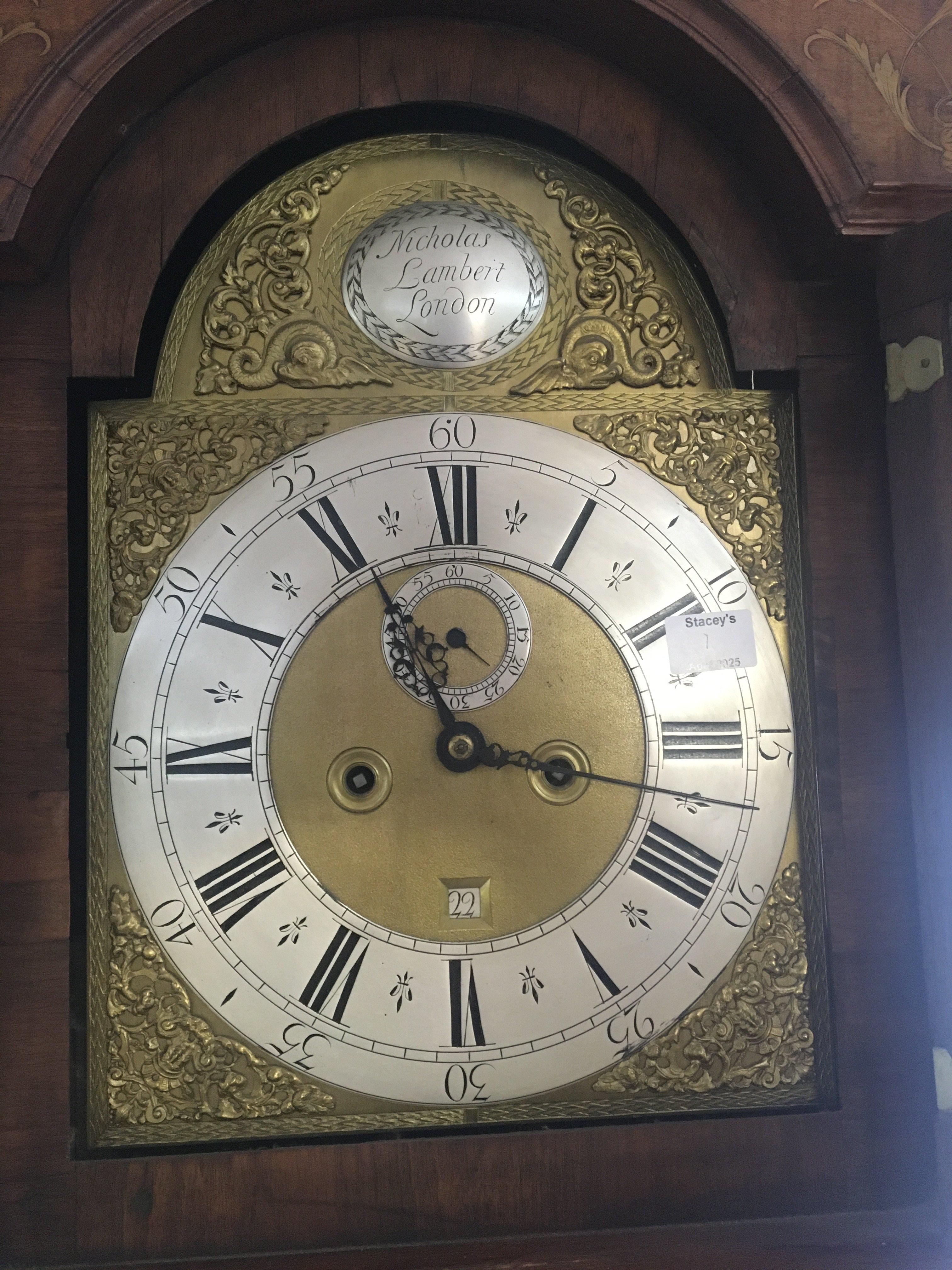 A Quality 18th century walnut long case clock the case with fine kingwood and satinwood floral inlay the hood with raised finials maker Nicholas Lambert London with arched brass dial silvered chapter ring date aperture. the movement eight day going striking on a bell with weights and pendulum.