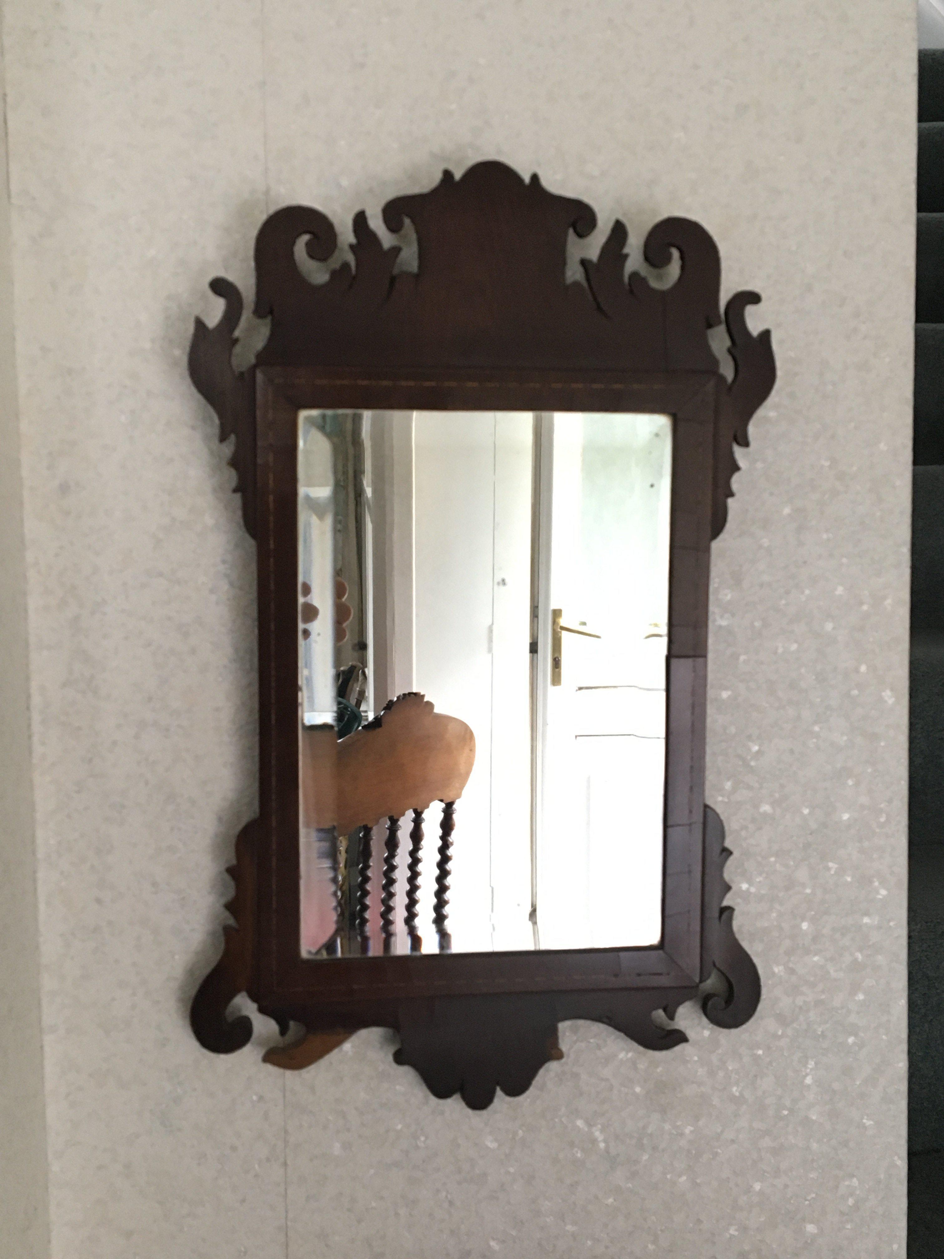 A George III wall mirror with pierced scroll cresting and of rectangular shape. 51x31cm