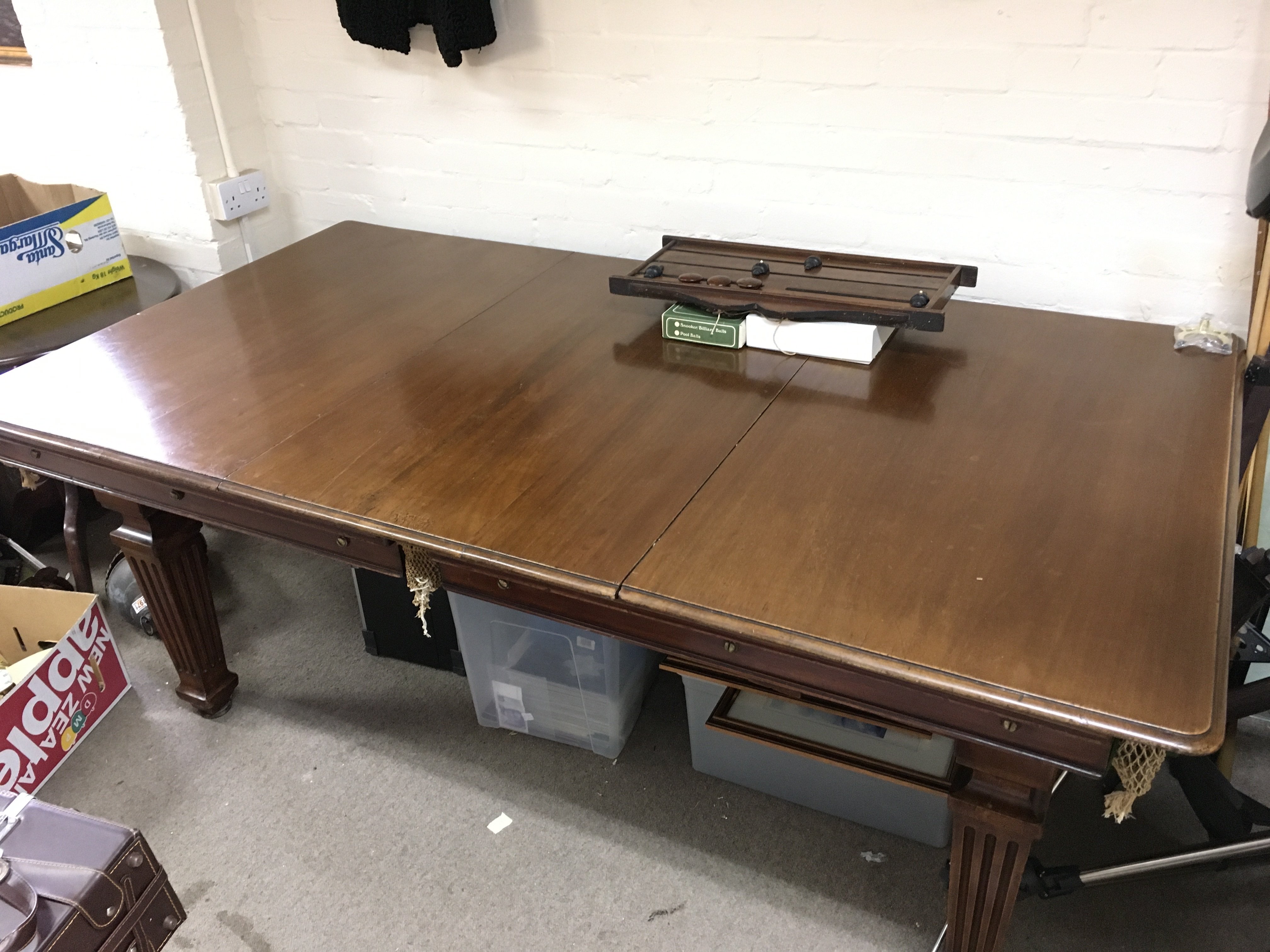 An early 20th century mahogany rising top snooker dining table with balls, cues and a scoreboard . 103cm wide 194cm long 75cm tall.