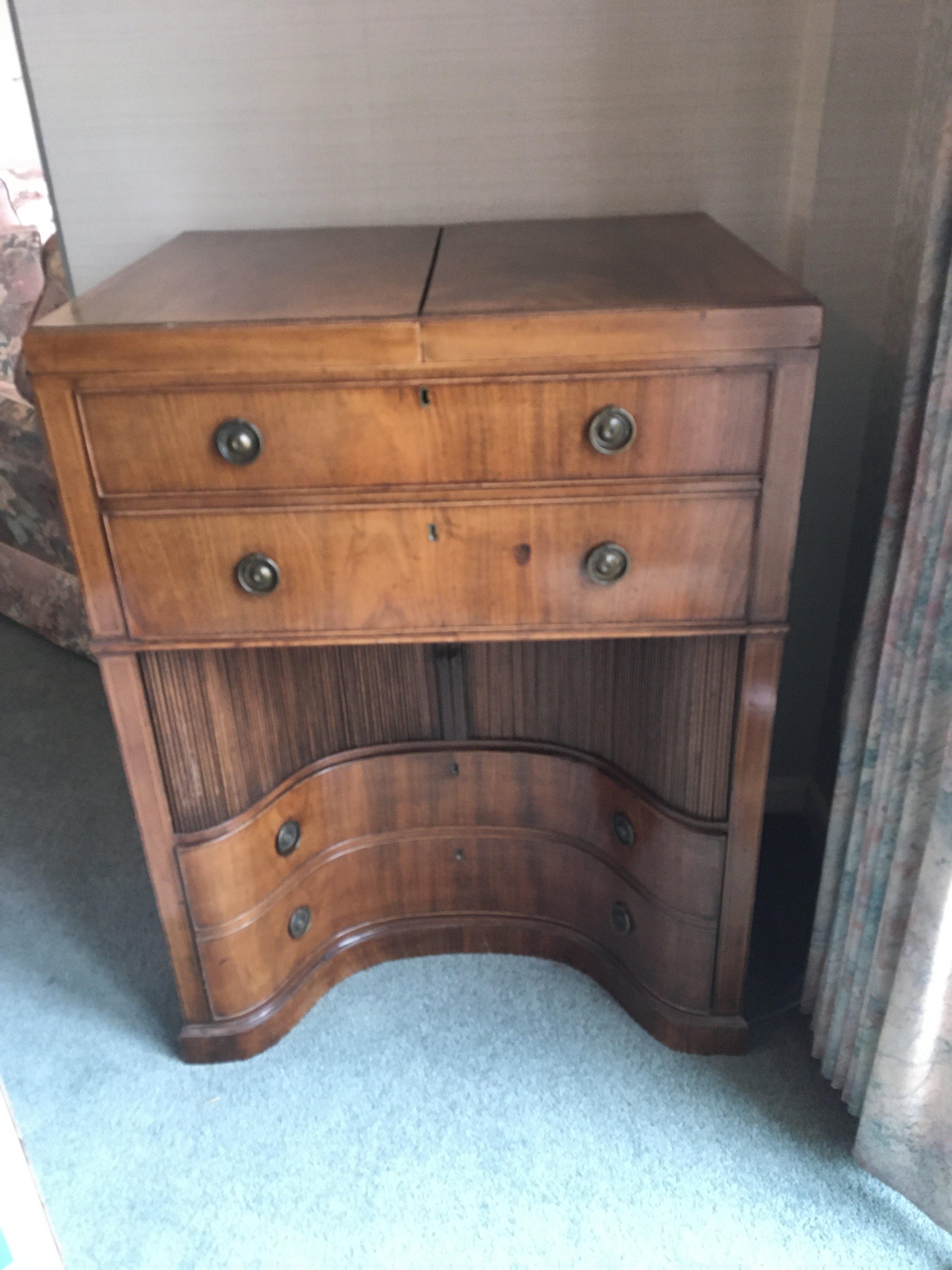 A George III mahogany traveling dressing chest with a hinged top above a well fitted interior and drawers with a sliding tambour inverted cupboard.