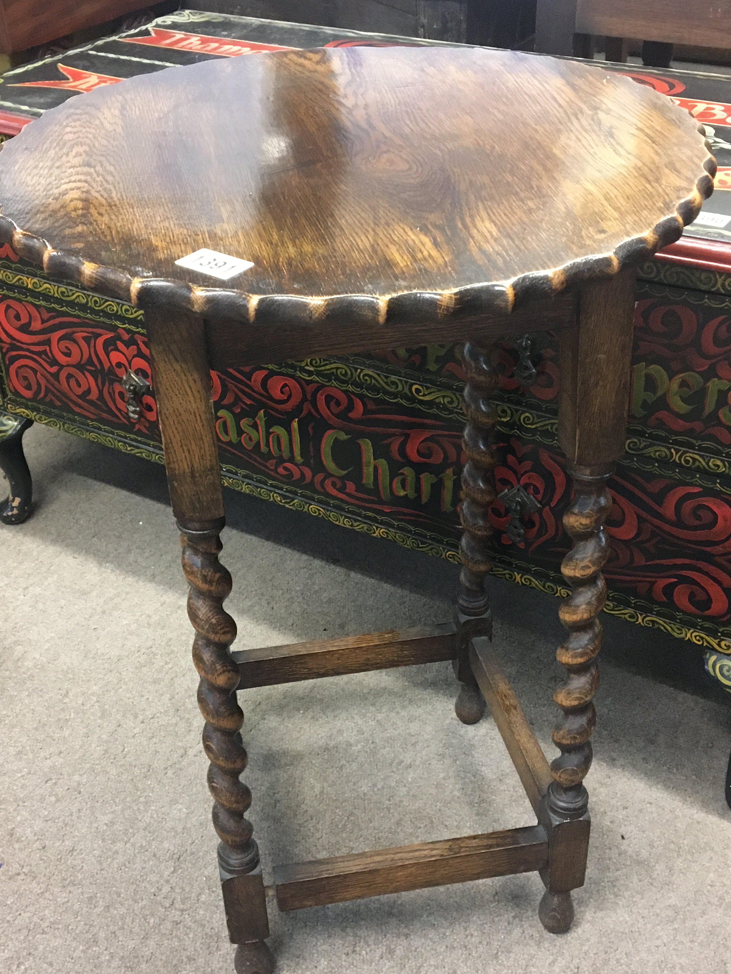 An oak occasional table the shaped top on barley twist legs.