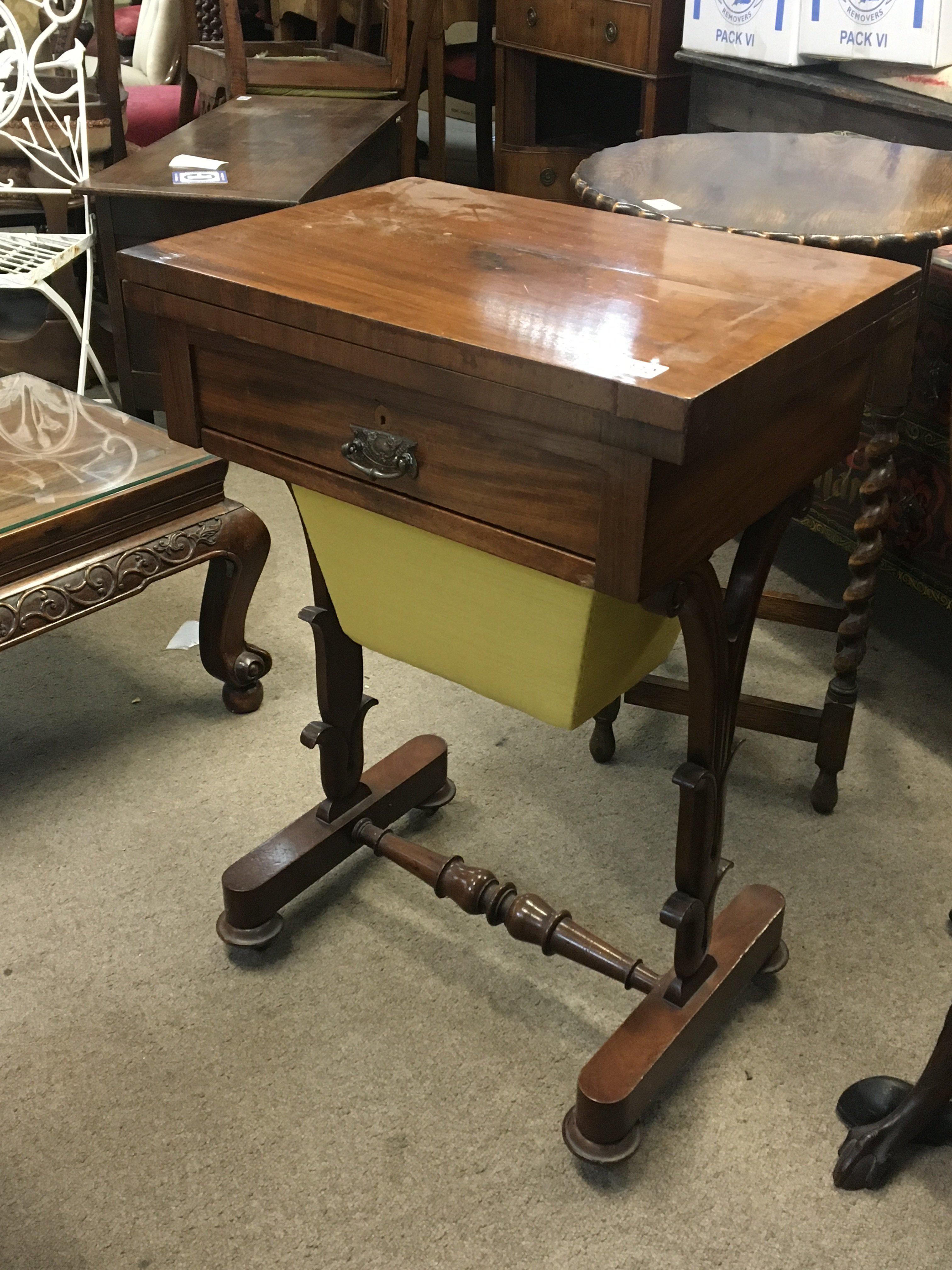 A Victorian mahogany work box games table the hinged top with a green above a single drawer on shaped supports.