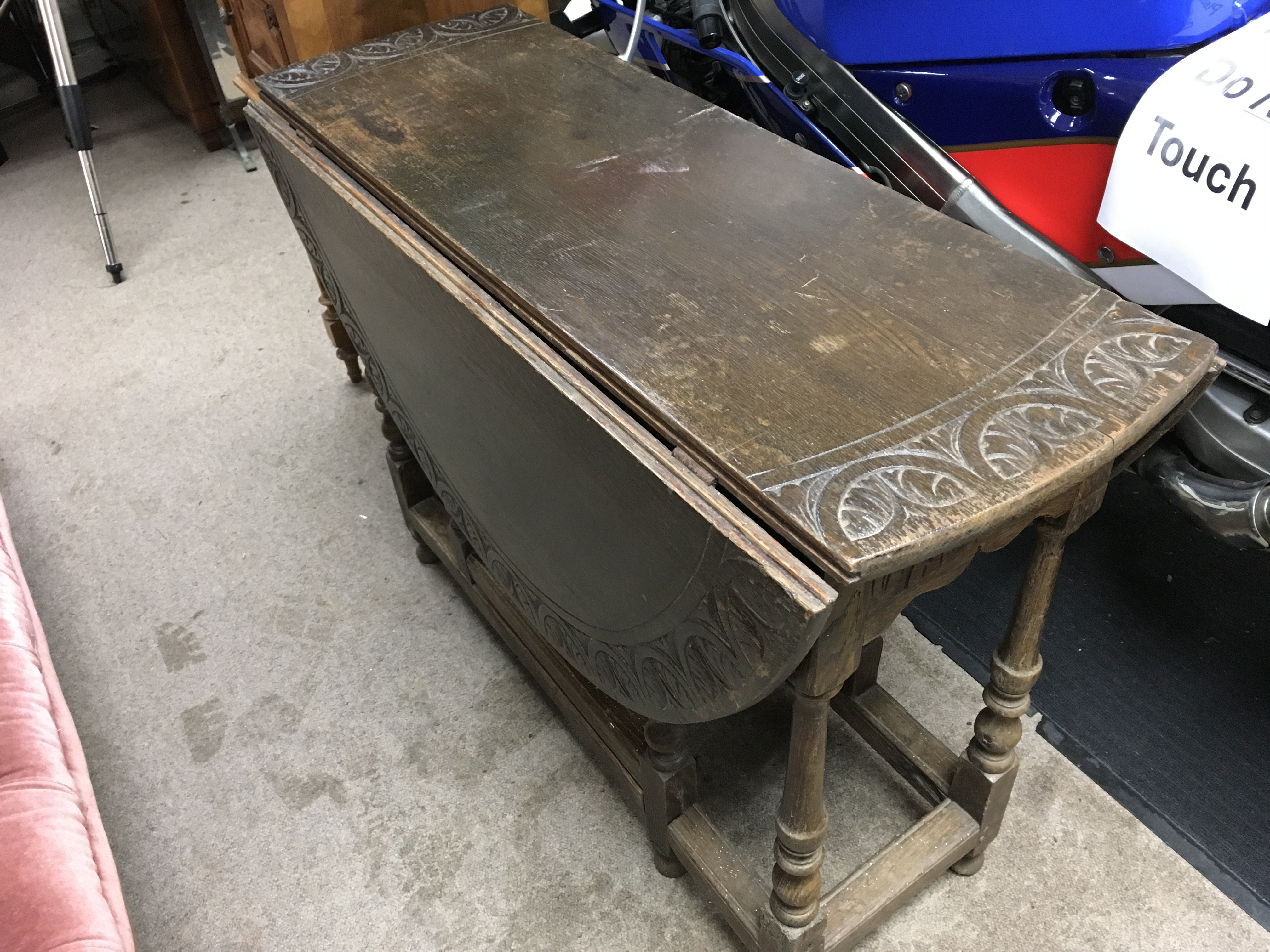 An oak 18th century style drop leaf table with a carved design , single drawer and turned legs . 111cm long 94cm wide 70cm tall.
