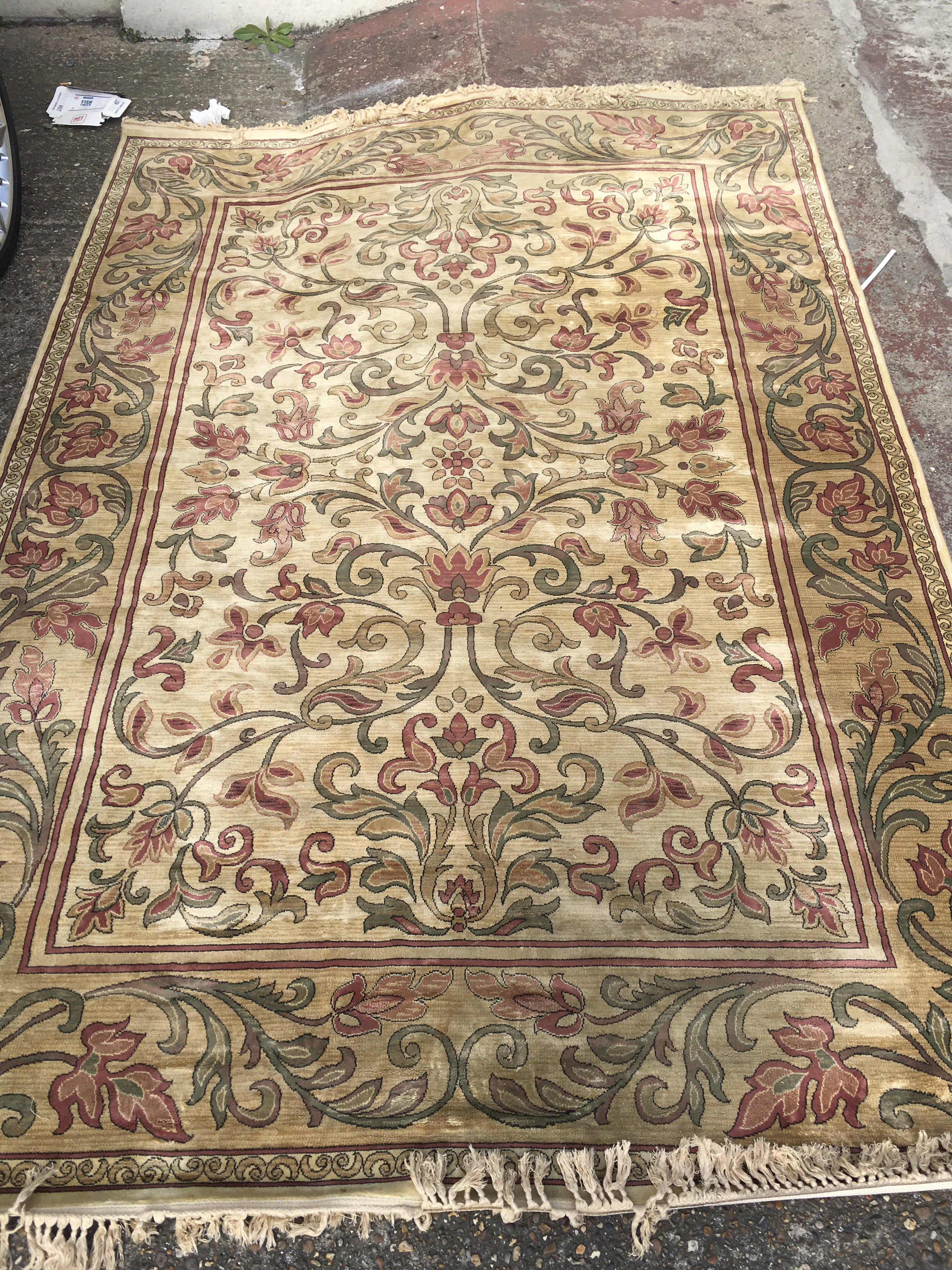 A silk carpet with central foliage pattern repeat pattern boards on a ivory field .6 ft 6 by 9 ft 6 .