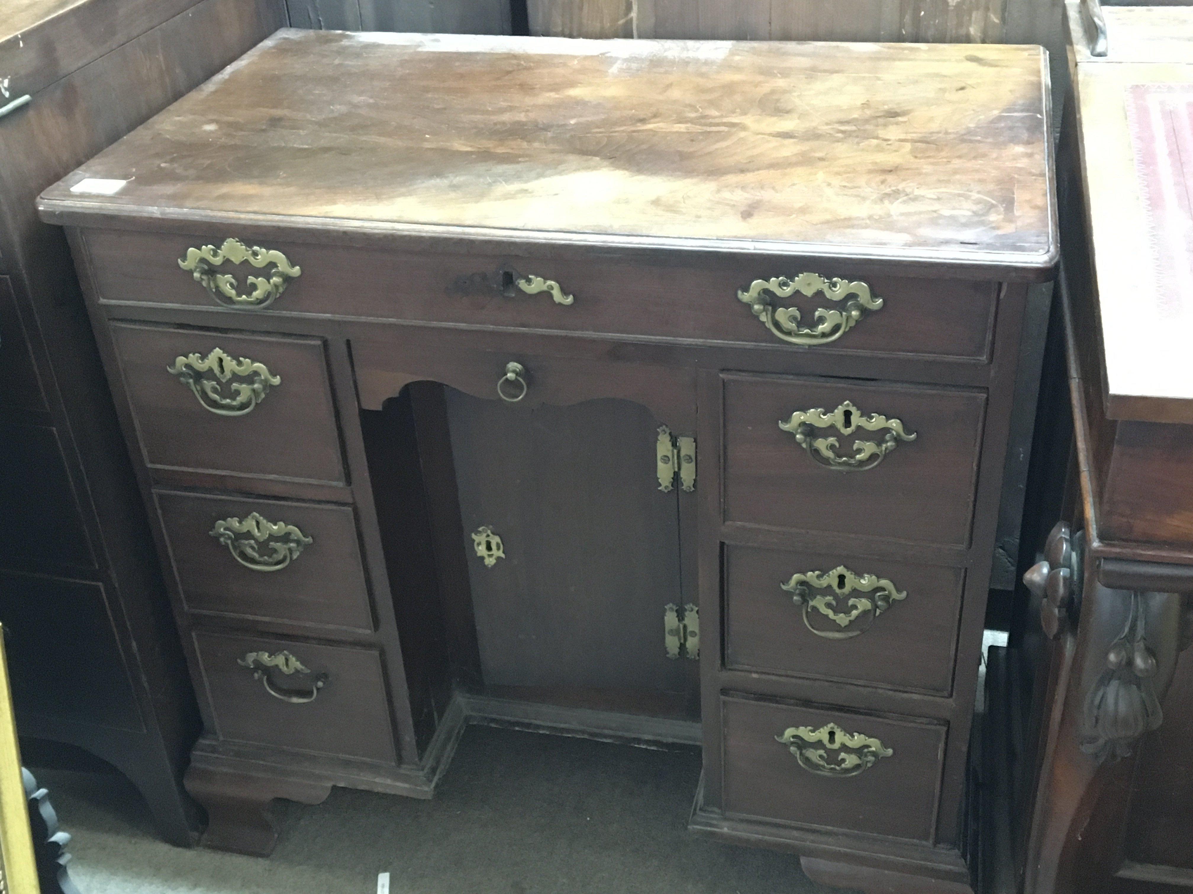 A George III 18th century red walnut Knee hole writing desk The rectangular top above flights of drawers and one long drawer on ogee bracket feet oak lined drawers. Width 79cm under 3ft.