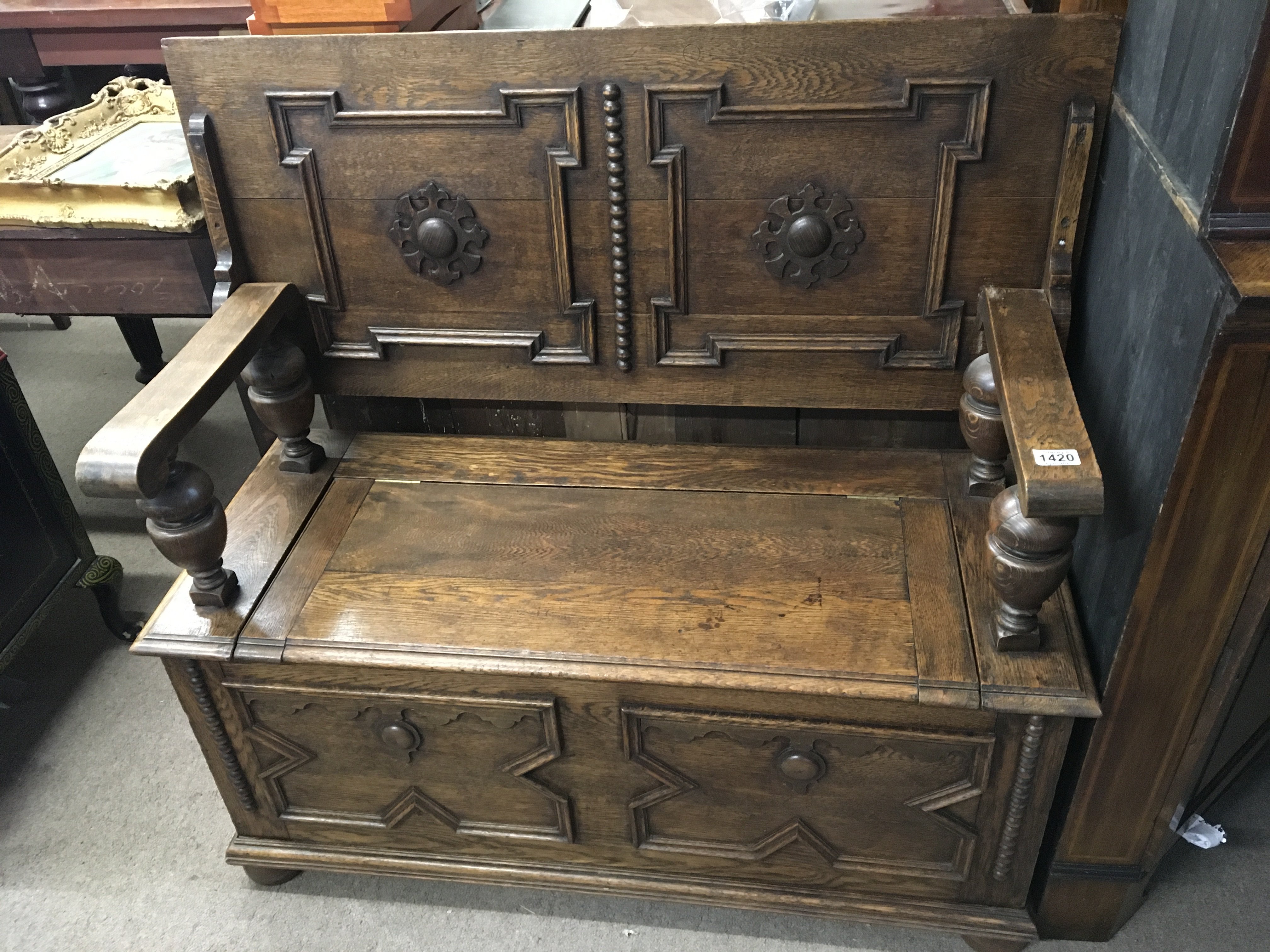 An Oak Hall seat with a hinged back and seat above applied moulding ornamentation. length 107cm