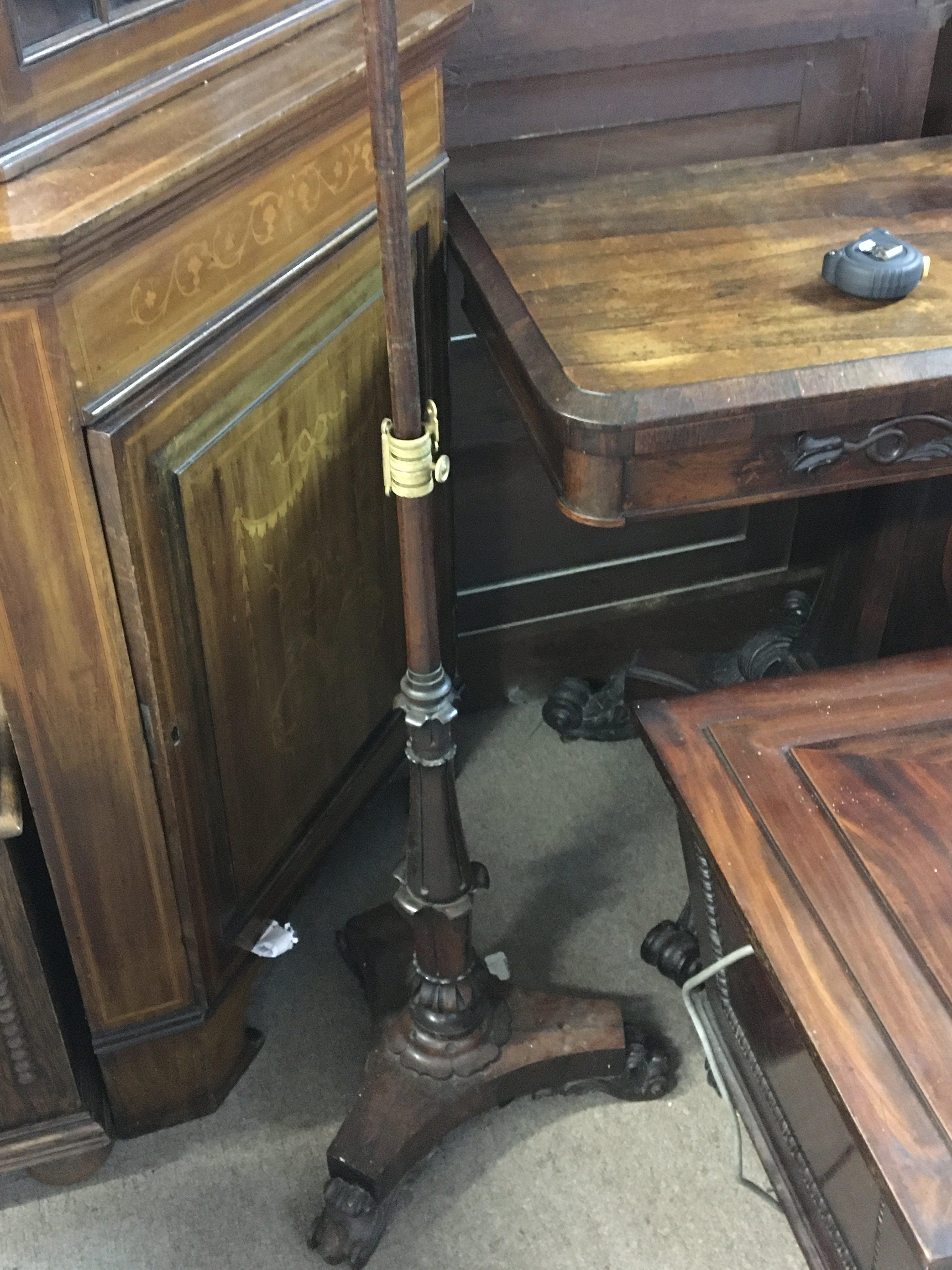 A William IV Rosewood pole screen with an elaborate support and scroll feet.