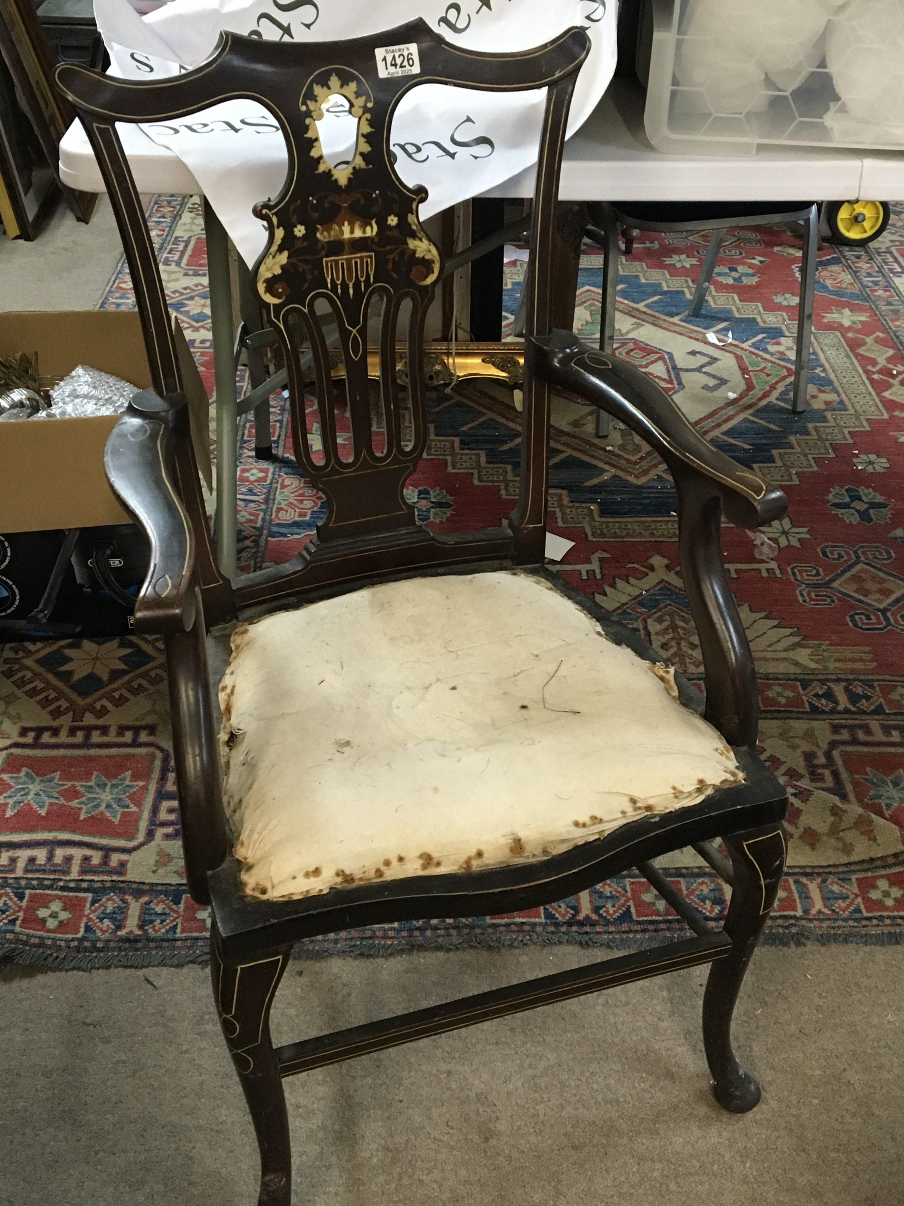 An Edwardian inlaid open arm chair with a shaped top rail and inlaid back.
