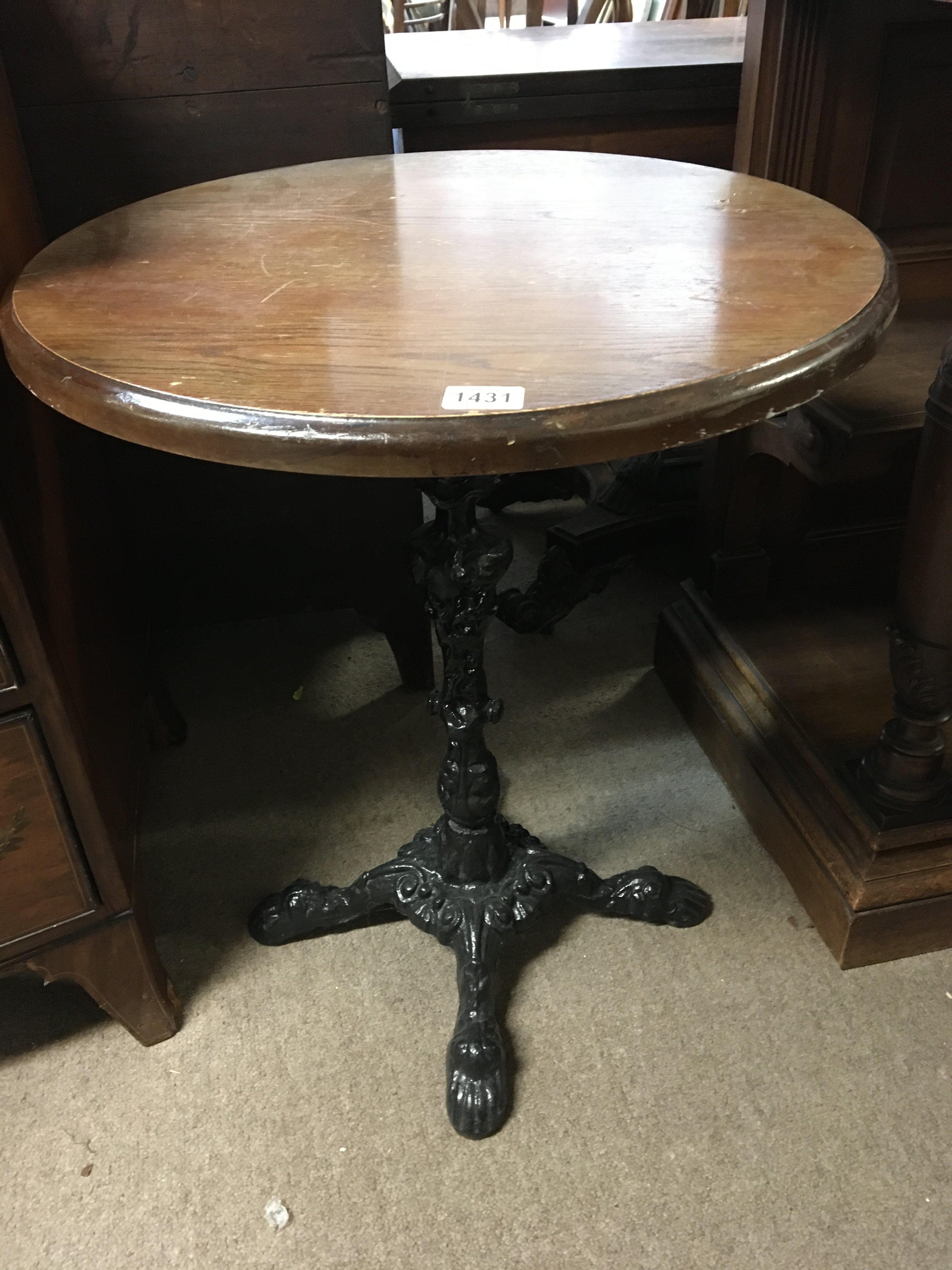 A pub type table with a circular wooden top on a wrought iron base. Top diameter 60cm wideNo Reserve
