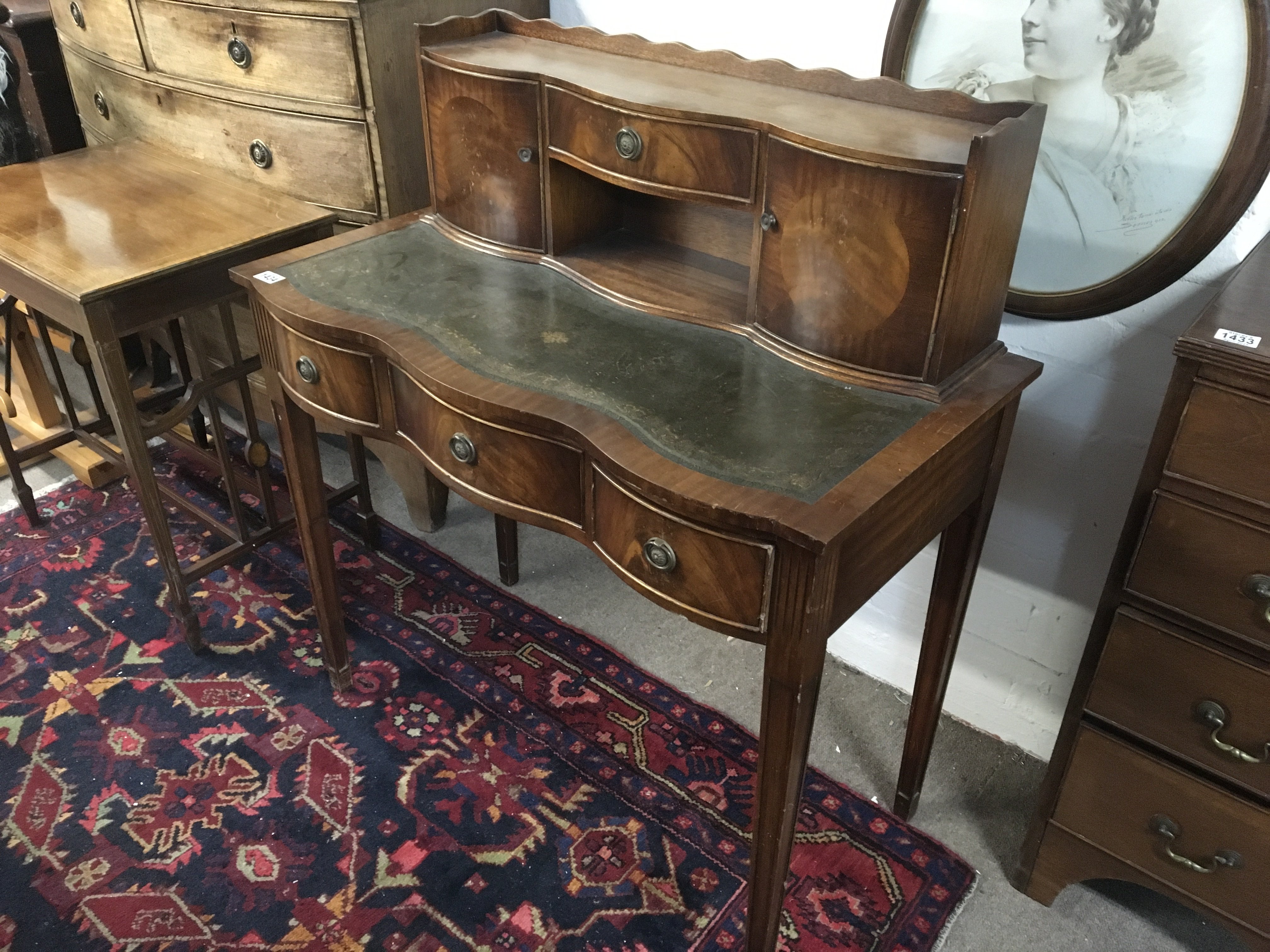 A Mahogany Carlton house type desk with a raised back fitted with drawers above a tooled leather top and three further drawers on square tapering legs.