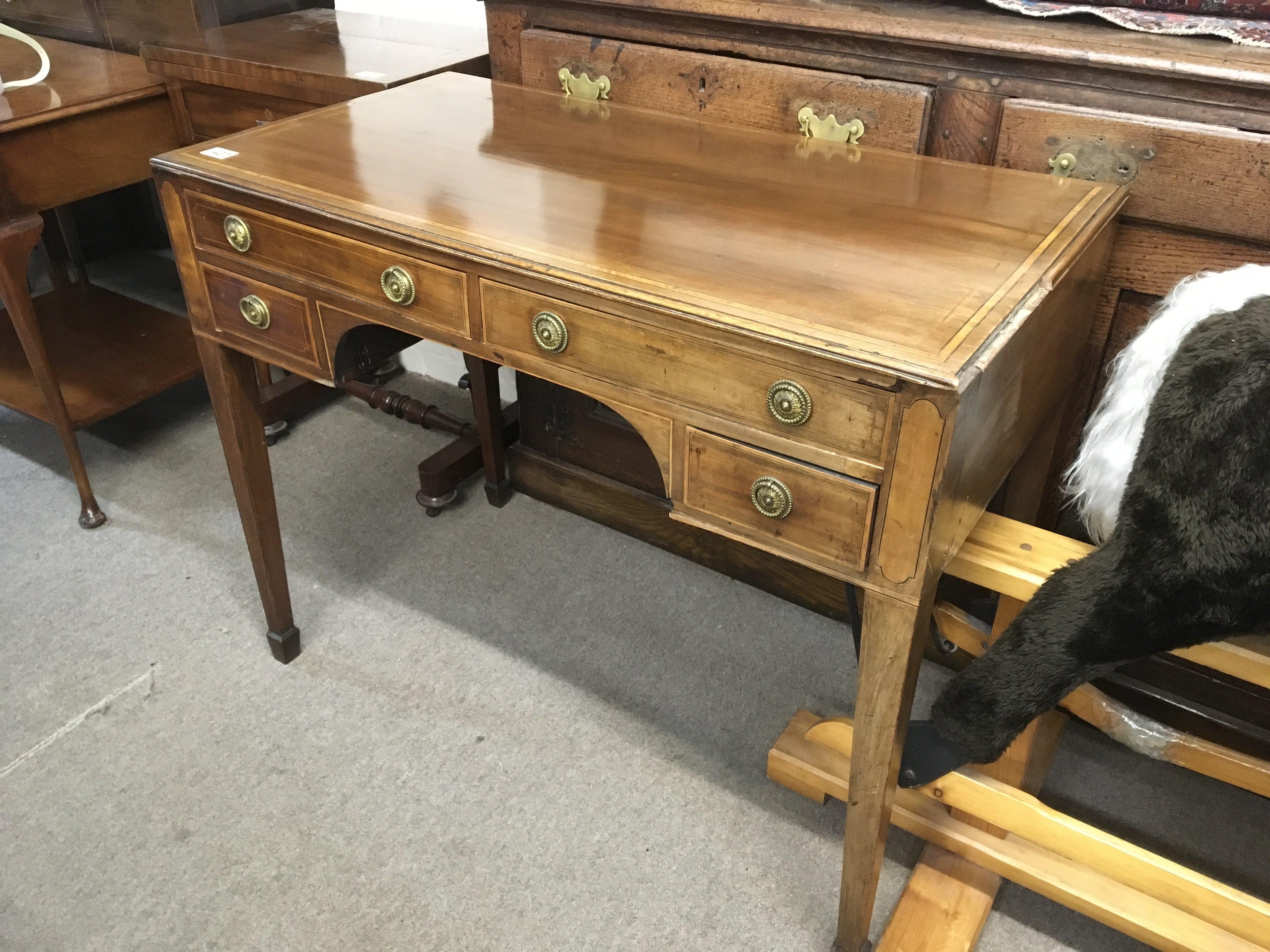 A 19th century mahogany and satinwood cross banded table fitted with four drawers on square tapering legs.