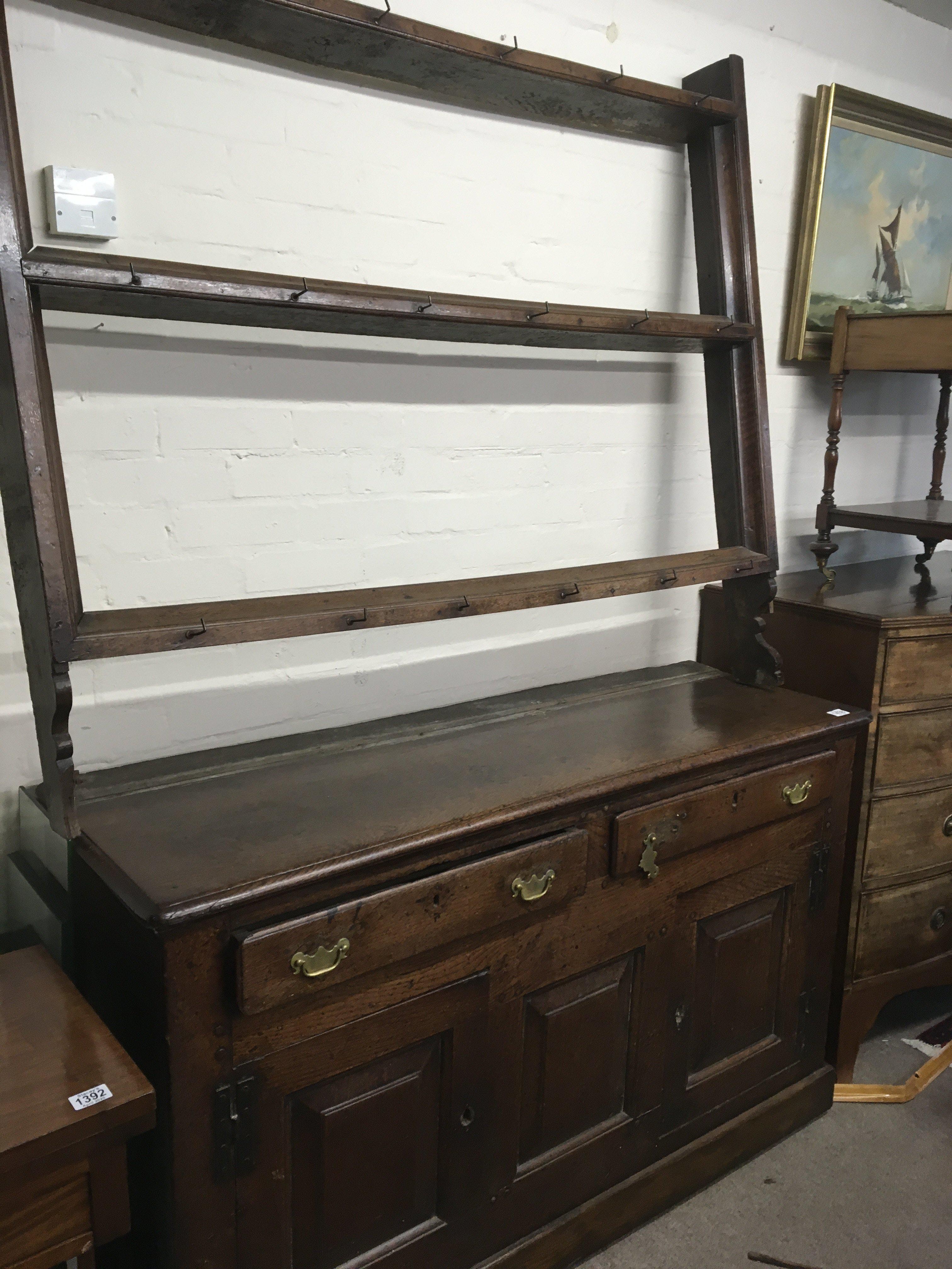 A Vernacular mid 18th century dresser in original condition possible North Wales with a raised open plate rack above two drawers with panel constructed cupboards external hinges. lots of original Caricature in keeping with age. Lenght 145cm