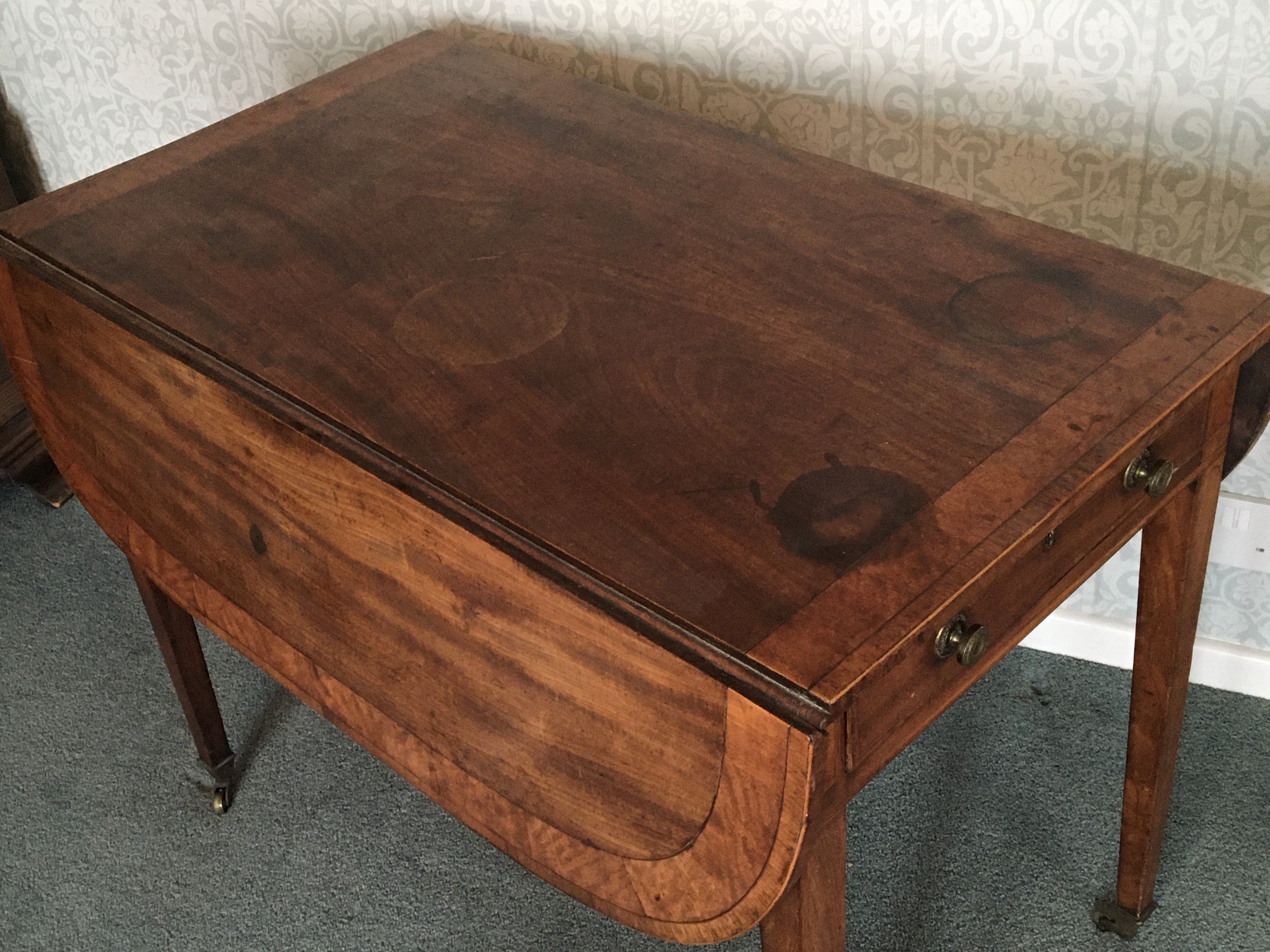 A George III mahogany Pembroke table the top with a wide cross banded edge on square legs.