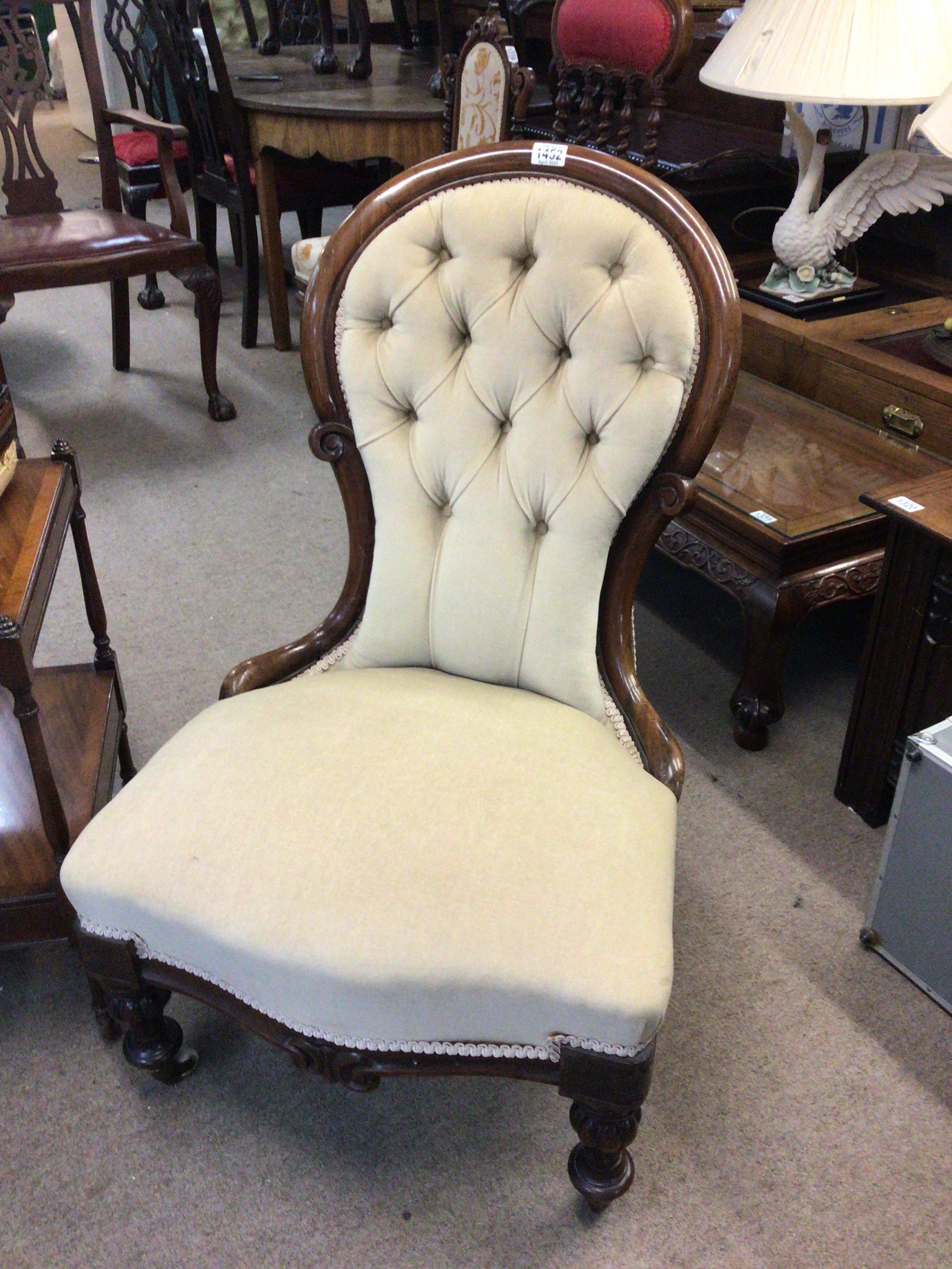 A Victorian walnut occasional chair with an upholstered back and seat on turned legs terminating in ceramic casters.