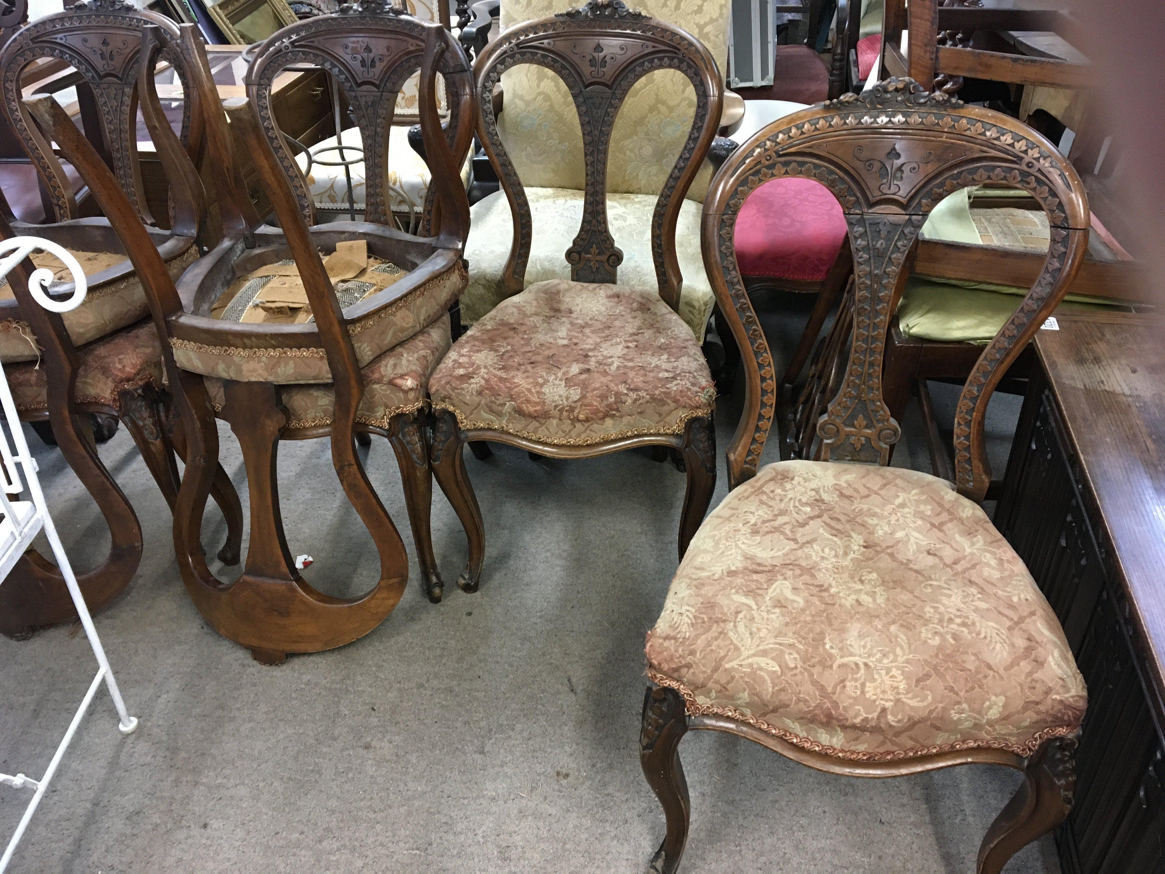 A set of six Victorian carved Irish walnut dinning chairs with shaped and carved backs above upholsterd seats on cabriol legs. (6)
