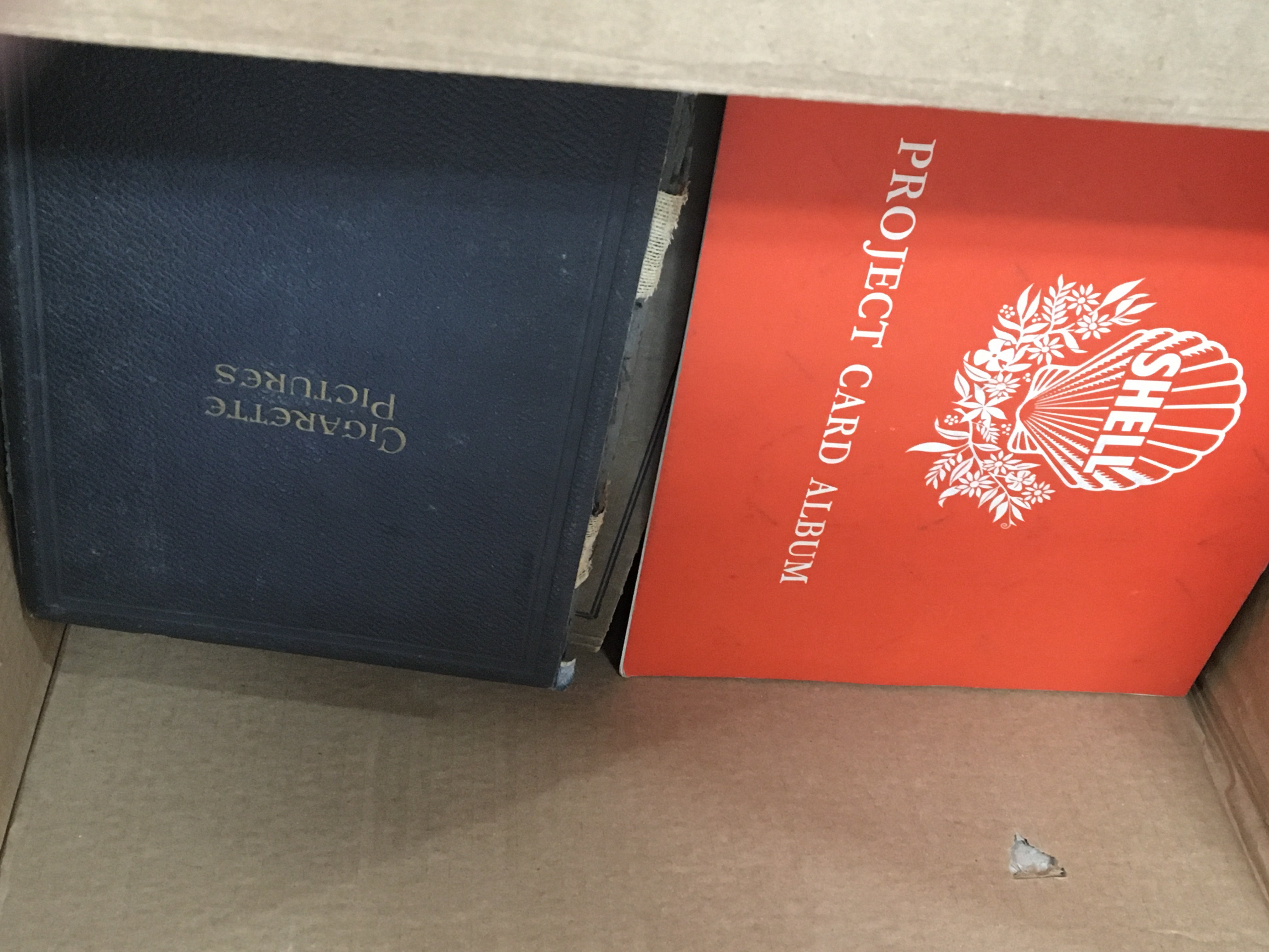 A box containing a large quantity of cigarette and tea card albums.