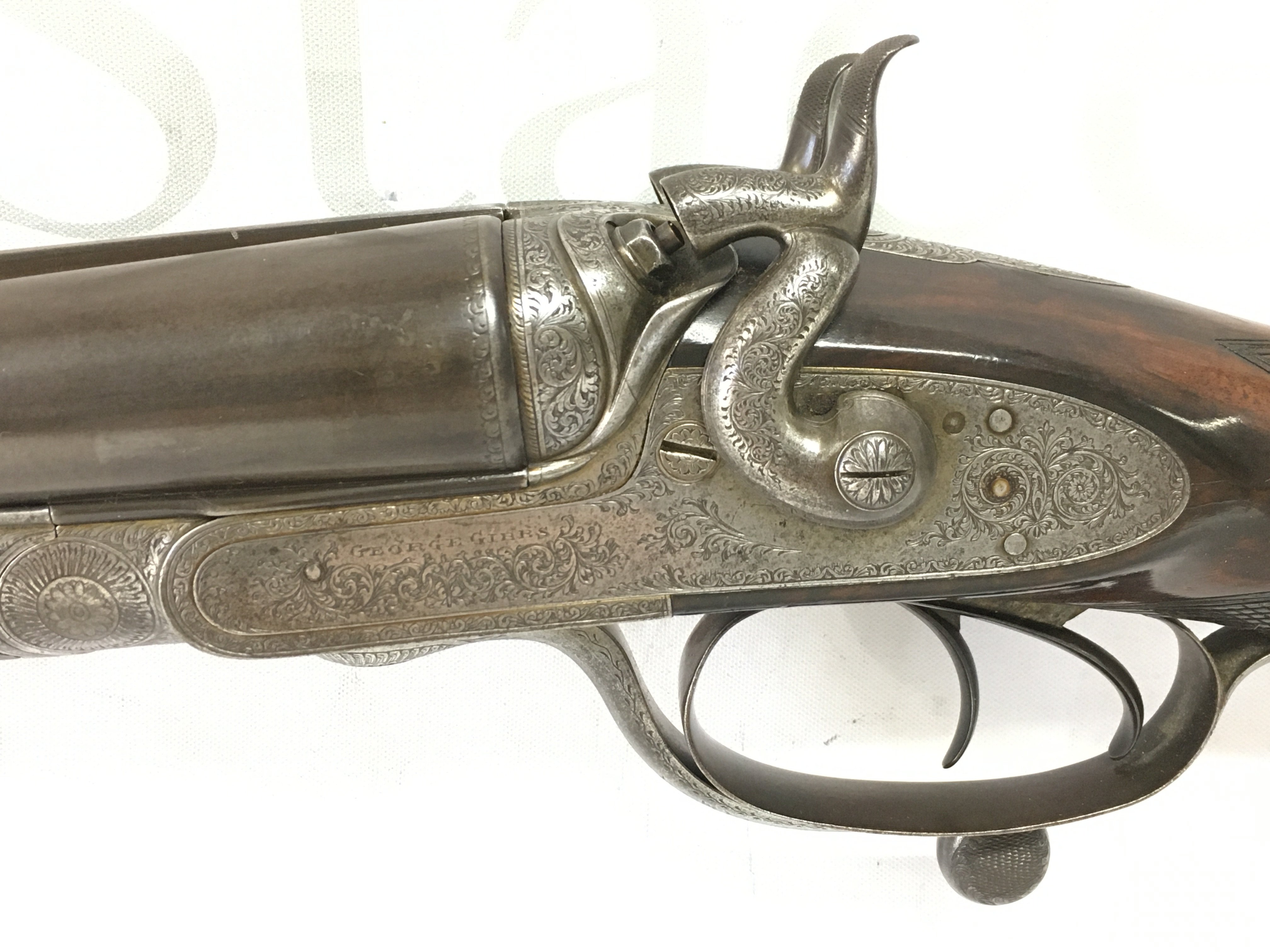A fine example of a gents 12 bore side by side hammer shotgun by George Gibbs. #6261 Features nice detailed scroll engraving to side and walnut stock. 28 inch barrel and 44.5 inch overall. PLEASE NOTE THAT A SHOTGUN LICENSE IS REQUIRED TO PURCHASE THIS ITEM. VIEWING AND COLLECTING IS BY APPOINTMENT ONLY.