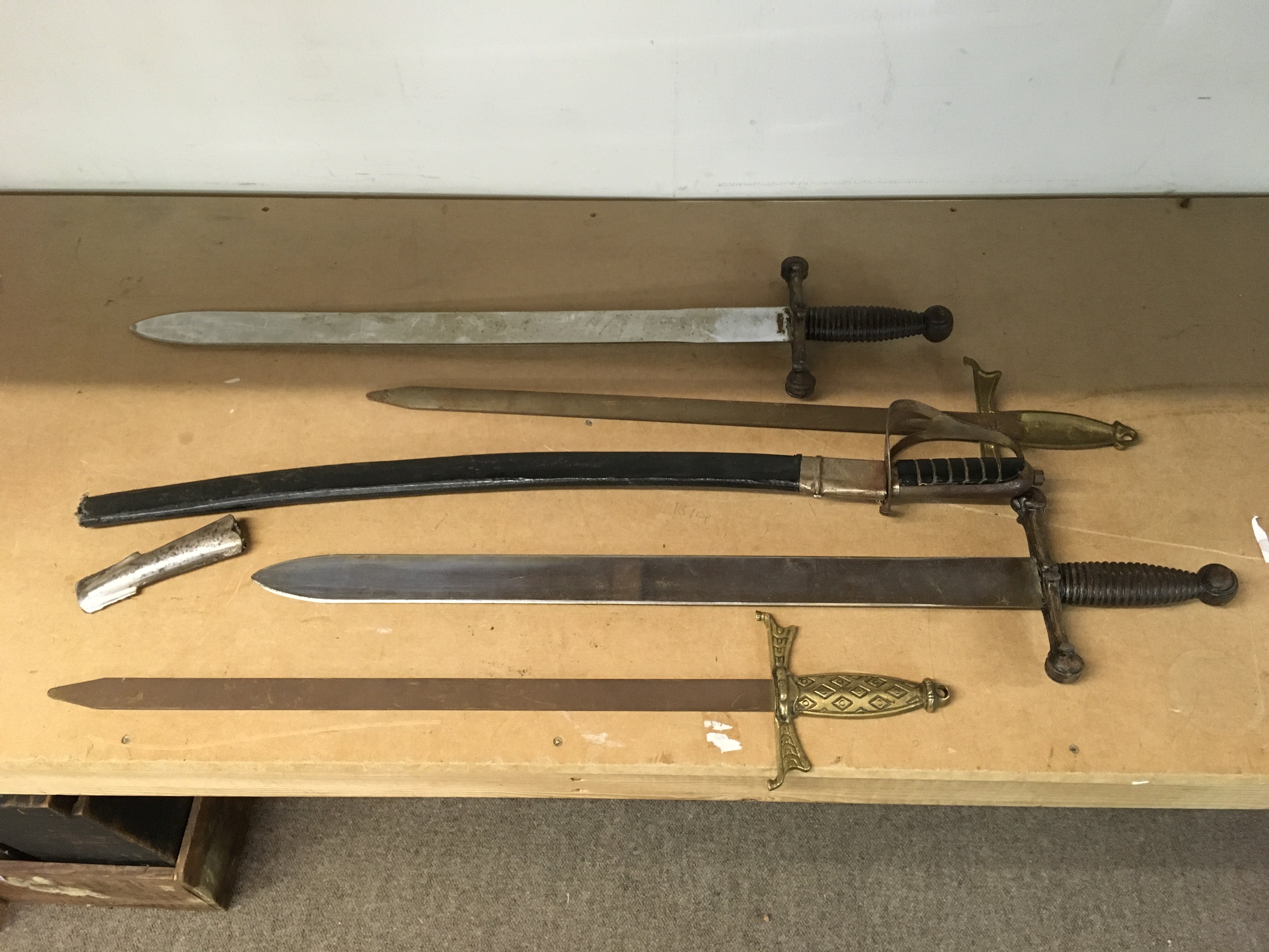 A collection of replica swords including an Indian sword, replica Roman style swords etc