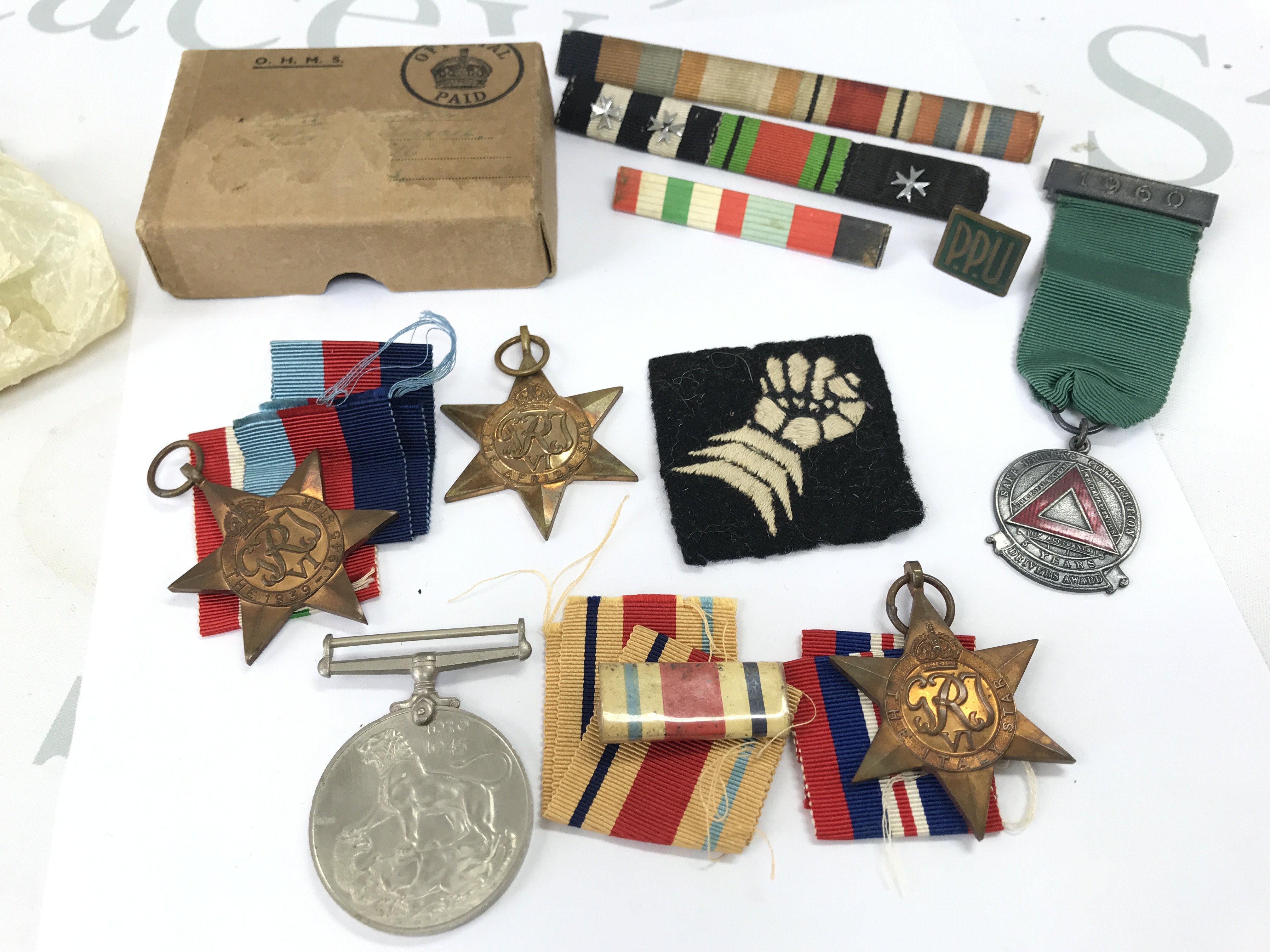 A WW2 medal group containing a Victory medal, 1939-45 star, Africa star, Italy star. Also including a 6th Armoured Brigade Cloth Formation Sign Patch Badge, 1960 Masonic safe driving medal. Postage category B