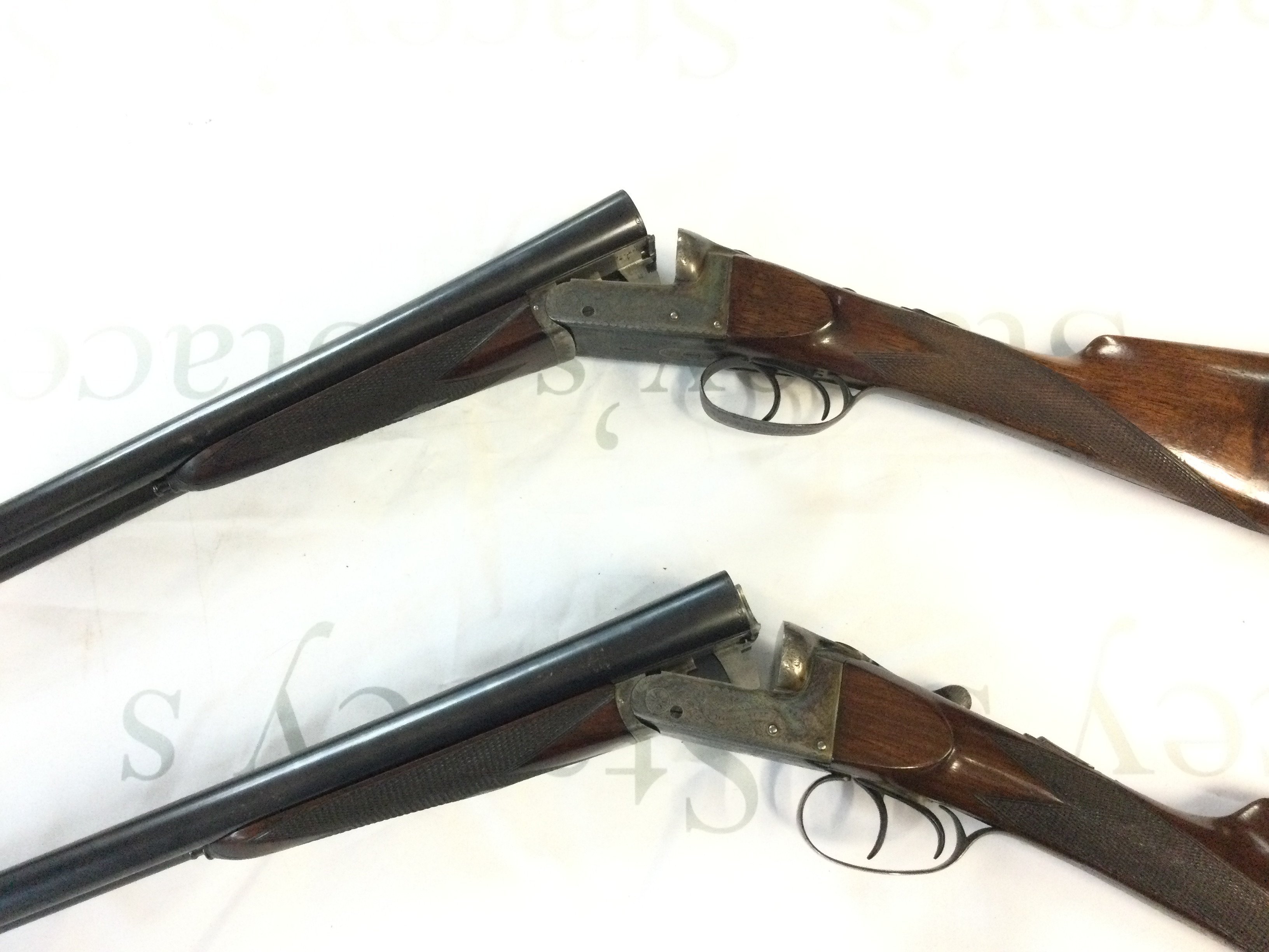 A pair of quality numbered 1 & 2 side by side shotguns attributed to churchill guns for Harrods Ltd in a fitted leather case. Walnut stock with chequered grip and twin triggers. 63cm barrels and 105cm overall length. PLEASE NOTE THAT A SHOGUN LICENSE IS REQUIRED TO PURCHASE THIS LOT. VIEWING AND COLLECTION IS BY APPOINTMENT ONLY.