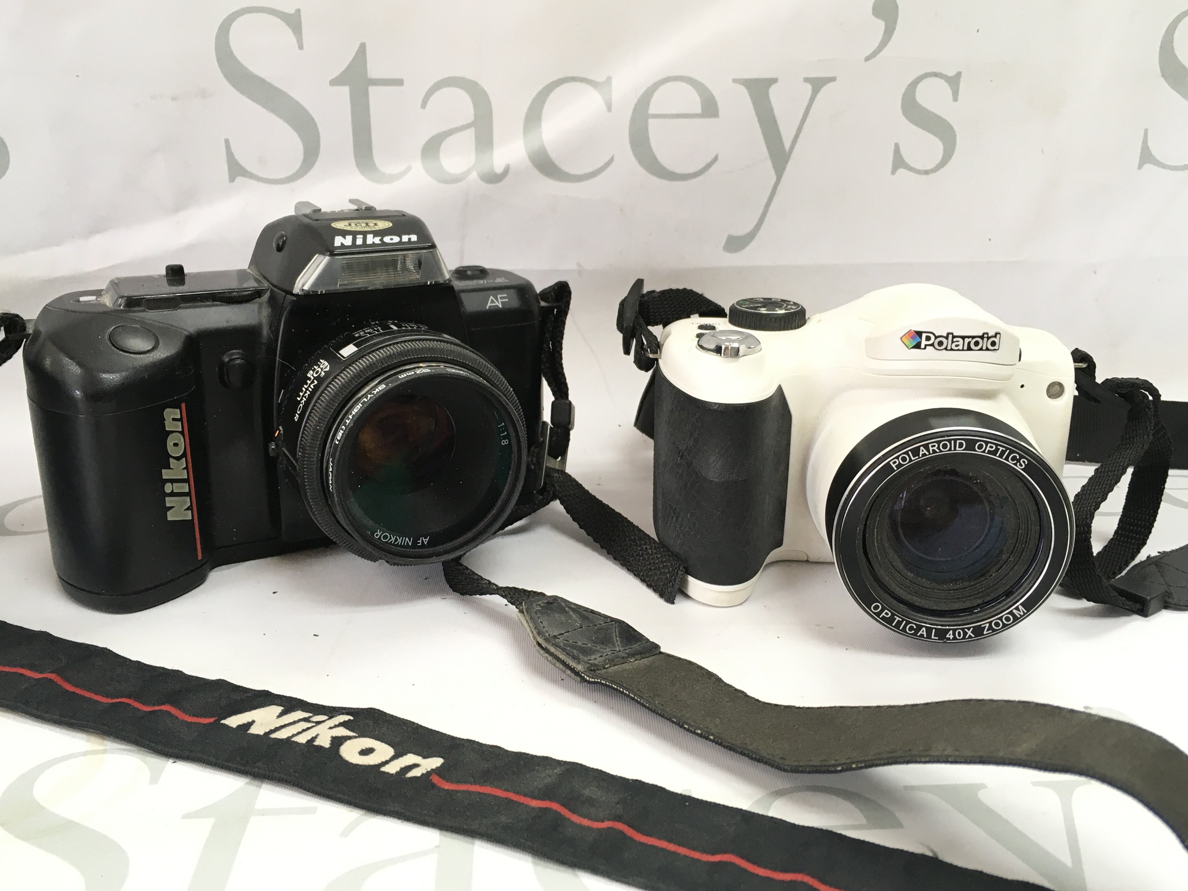 A Nikon F-401 camera and a Polaroid digital camera . Postage category B