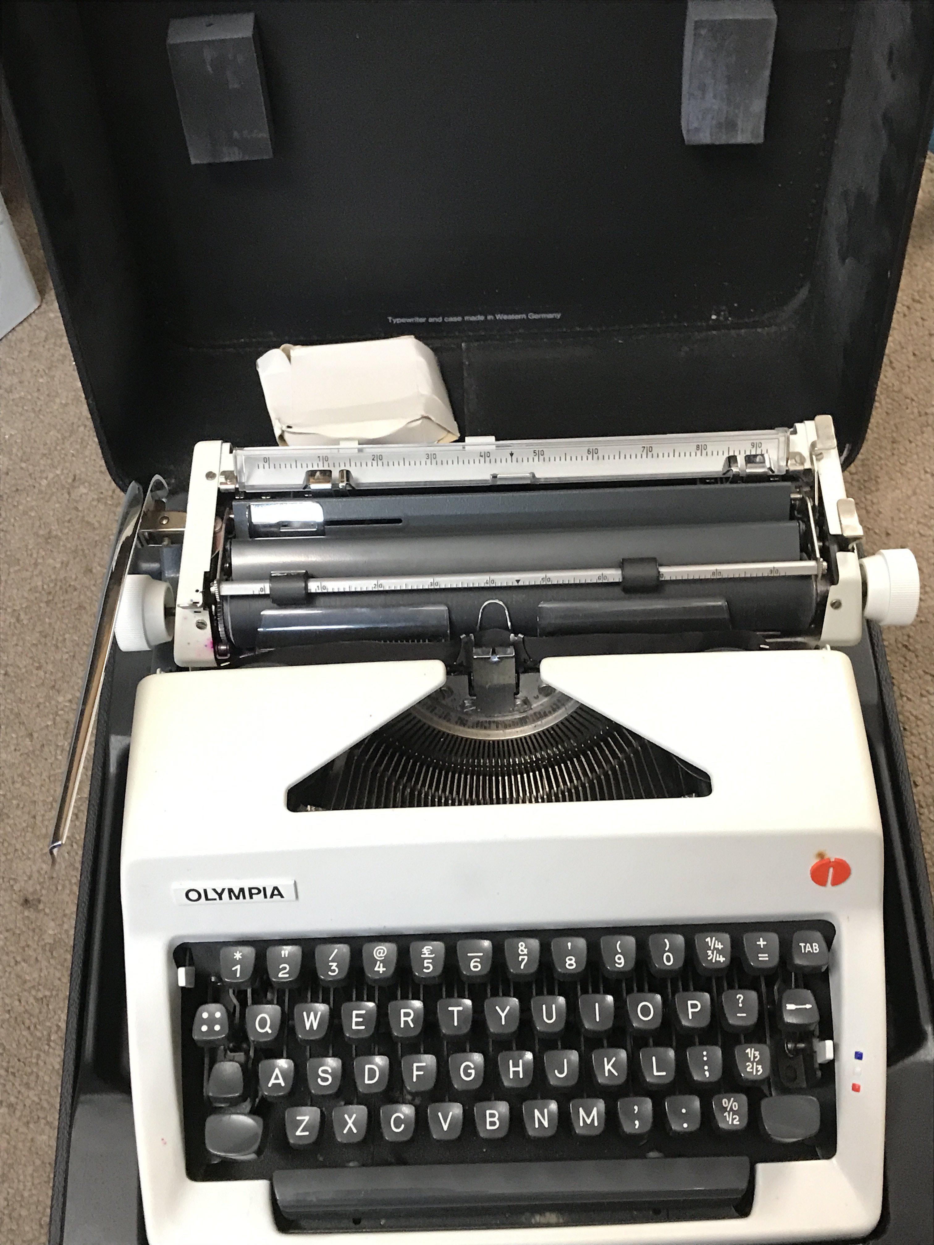 A Cased vintage Olympia typewriter. Postage category C