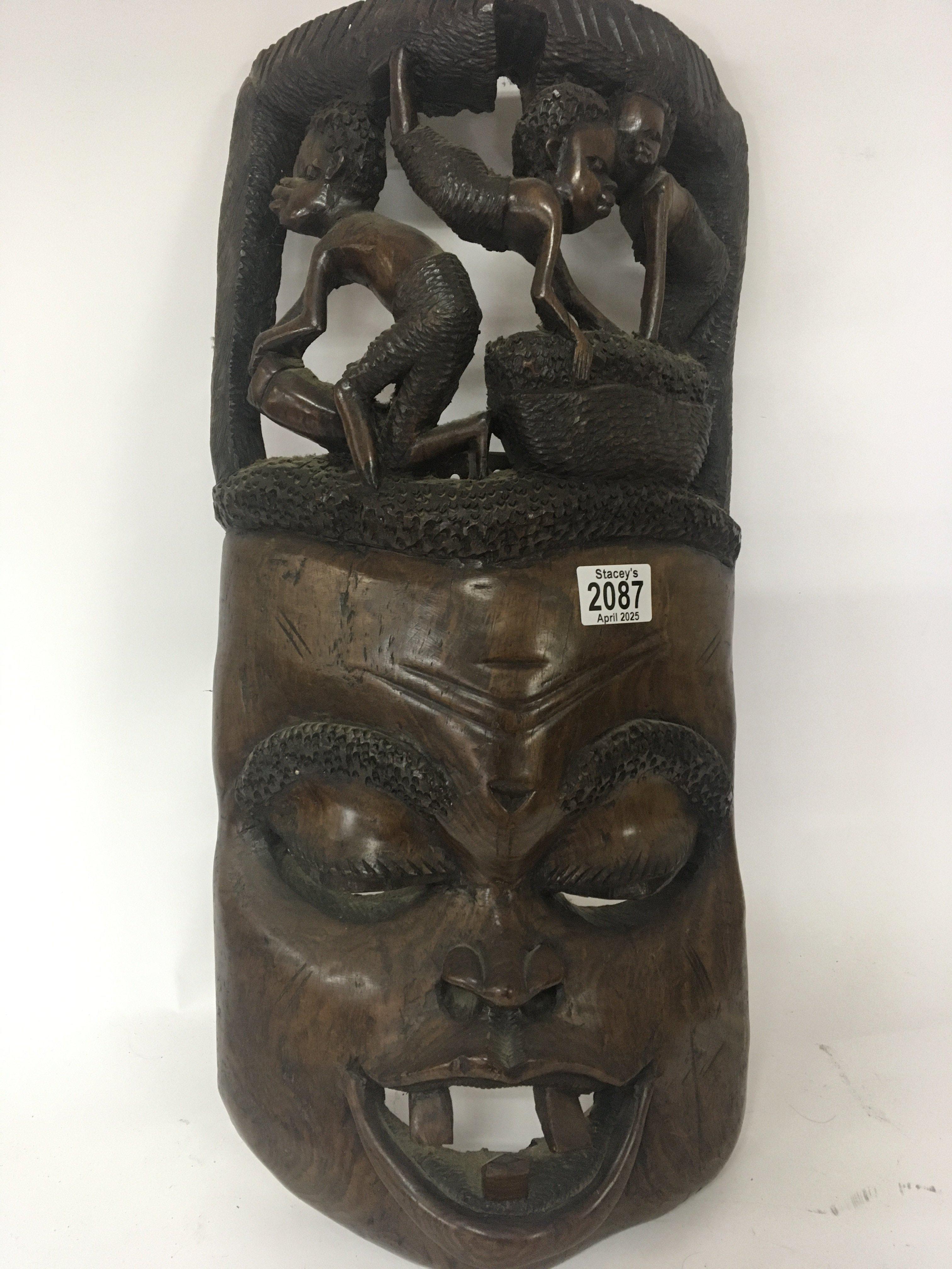 A large carved hardwood African wall mask the top with carved figures height 57cm