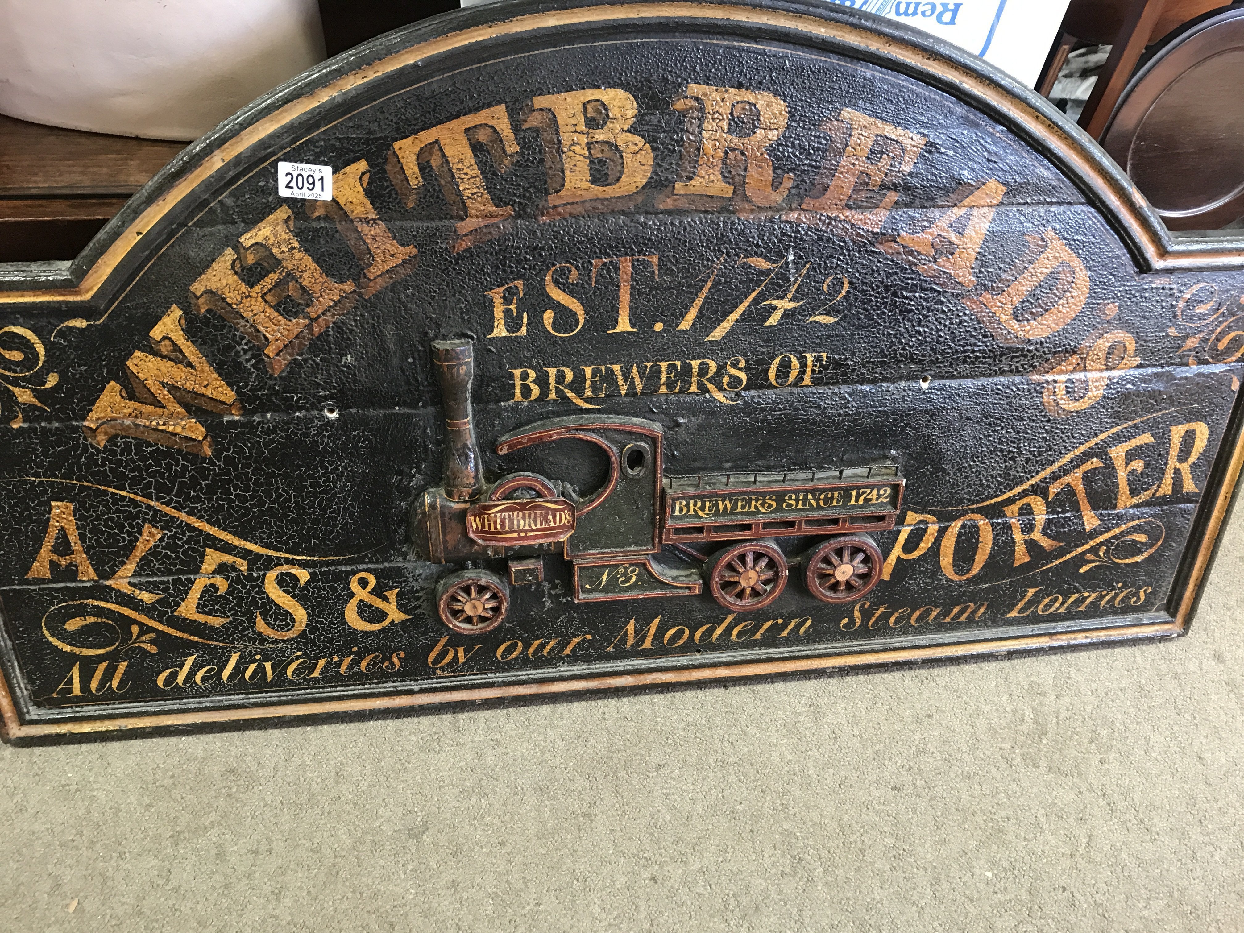 A wooden advertising sign Whitbreads all deliveries by our modern steam Lorries .